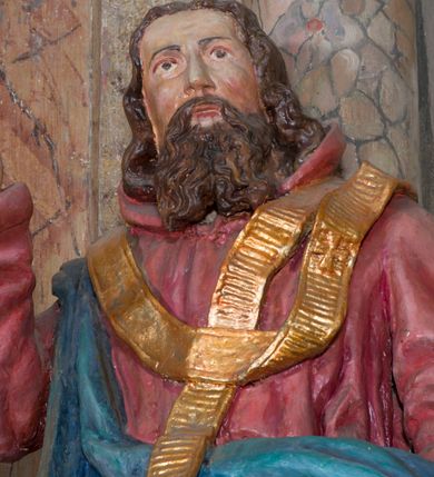 Zdjęcie nr 5: Rzeźba drążona, na cokole. Święty Metody został ukazany całopostaciowo, frontalnie, z głową zwróconą nieznacznie w lewo. Ma prostokątną twarz o jasnej karnacji, wysokim czole, brązowych oczach, prostym nosie i małych ustach. Falowana, ciemnobrązowa, rozdzielająca się w dwa pukle broda opada mu na pierś, a falowane włosy na ramiona i plecy. Jest ubrany w długi, ciemnoczerwony habit przewiązany w pasie, z kapturem wyłożonym na plecy. Habit opada do ziemi, łamiąc się w grube fałdy, na nim ma przewieszony złoty paliusz. Spod habitu wystają fragmenty odzianych w sandały stóp. Na habit ma zarzucony przez prawe ramię, udrapowany płaszcz w kolorze niebieskim. Metody unosi prawą dłoń w geście błogosławieństwa, lewą podtrzymuje fałdy płaszcza. Polichromia w partiach ciała naturalistyczna.