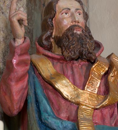 Zdjęcie nr 4: Rzeźba drążona, na cokole. Święty Metody został ukazany całopostaciowo, frontalnie, z głową zwróconą nieznacznie w lewo. Ma prostokątną twarz o jasnej karnacji, wysokim czole, brązowych oczach, prostym nosie i małych ustach. Falowana, ciemnobrązowa, rozdzielająca się w dwa pukle broda opada mu na pierś, a falowane włosy na ramiona i plecy. Jest ubrany w długi, ciemnoczerwony habit przewiązany w pasie, z kapturem wyłożonym na plecy. Habit opada do ziemi, łamiąc się w grube fałdy, na nim ma przewieszony złoty paliusz. Spod habitu wystają fragmenty odzianych w sandały stóp. Na habit ma zarzucony przez prawe ramię, udrapowany płaszcz w kolorze niebieskim. Metody unosi prawą dłoń w geście błogosławieństwa, lewą podtrzymuje fałdy płaszcza. Polichromia w partiach ciała naturalistyczna.