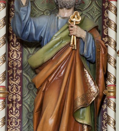 Zdjęcie nr 1: Rzeźba pełna na cokole przedstawiająca św. Piotra ukazanego w całej postaci, frontalnie, z głową przechyloną nieznacznie na lewo. Święty prawą rękę unosi w geście błogosławieństwa, w lewej trzyma dwa klucze. Ma prostokątną twarz z niebieskimi szeroko otwartymi oczami, prostym nosem oraz wąskimi, czerwonymi ustami. Okalają ją siwe włosy, które spływając falami zasłaniają uszy oraz siwa, krótka broda i wąsy. Jest ubrany w niebieską tunikę z szerokimi rękawami i złotą lamówką oraz podbity zielonym materiałem brązowy płaszcz, dekorowany złotą lamówką i bordiurą z ornamentem roślinnym tej samej barwy, przechodzący przez lewy bark i wokół prawego biodra. Tkaniny gną się w grube fałdy. W partiach ciała polichromia naturalistyczna, klucze złocone. 