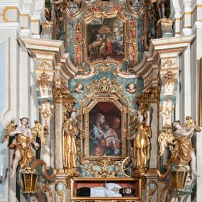 Zdjęcie nr 1: Ołtarz architektoniczny, jednoosiowy, jednokondygnacyjny ze zwieńczeniem, na cokole. Mensa drewniana umieszczona na drewnianej tumbie o wklęsło-wypukłych bokach. Antependium dekorowane rocaille’owym kartuszem z rytym gorejącym sercem, brzegi zdobione rocaille’em. W predelli przeszklona trumienka z figurą św. Jana Nepomucena, w profilowanej, złoconej ramie, na rocaillowej podstawie. Nastawa ujęta parami występujących do przodu filarów: wewnętrzne filary opięte pilastrami; zewnętrzne filary z wolutami zamiast trzonów, z figurami aniołów. Podpory dźwigają pełne belkowanie, przerwane nad polem środkowym. W polu nisza w kształcie stojącego prostokąta zamkniętego trójbocznie, w której obraz Święta Rodzina w profilowanej ramie. Przy filarach od wewnątrz rocaille’owe konsole z figurami św. Doroty i św. Katarzyny Aleksandryjskiej. Zwieńczenie w formie aedikuli zbliżonej do kwadratu o fantazyjnym wklęsło-wypukłym zamknięciu; ujęte pilastrami przechodzącymi w spływy wolutowe, opadające na belkowanie, tworzące postumenty dla figur św. Stefana i św. Emeryka. W polu zwieńczenia obraz z przedstawieniem Świętej Rodziny przy pracy, w kształcie kwadratu o wklęsłych narożach, w profilowanej ramie. Zwieńczenie zamknięte glorią promienistą z literami IHS w otoczeniu obłoków; na osi pilastrów rokokowe wazony z różami.W partii cokołów kanony w rocaille’owych ramach. Trzony pilastrów i woluty dekorowane rocaille’owymi płycinami, we fryzie rocaille. Nisza w polu środkowym ujęta rocaille’ami, zwieńczona mitrą książęcą, flankowana przez parę uskrzydlonych główek anielskich. Woluty zwieńczenia dekorowane motywami rocaille’ów. Rama obrazu w polu ujęta małżowiną, ornamentem roślinnym i rocaille’ami. Struktura marmoryzowana w odcieniu jasnoniebieskim, podpory, tumba i cokoły w odcieniu kości słoniowej; ornamentyka i profile złocone.