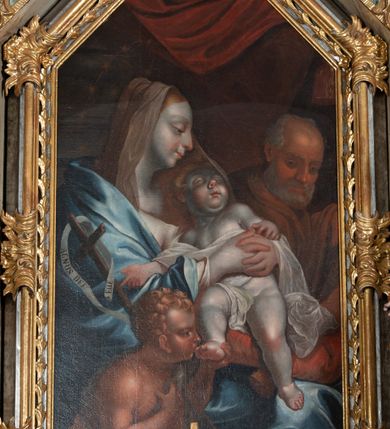 Zdjęcie nr 6: Ołtarz architektoniczny, jednoosiowy, jednokondygnacyjny ze zwieńczeniem, na cokole. Mensa drewniana umieszczona na drewnianej tumbie o wklęsło-wypukłych bokach. Antependium dekorowane rocaille’owym kartuszem z rytym gorejącym sercem, brzegi zdobione rocaille’em. W predelli przeszklona trumienka z figurą św. Jana Nepomucena, w profilowanej, złoconej ramie, na rocaillowej podstawie. Nastawa ujęta parami występujących do przodu filarów: wewnętrzne filary opięte pilastrami; zewnętrzne filary z wolutami zamiast trzonów, z figurami aniołów. Podpory dźwigają pełne belkowanie, przerwane nad polem środkowym. W polu nisza w kształcie stojącego prostokąta zamkniętego trójbocznie, w której obraz Święta Rodzina w profilowanej ramie. Przy filarach od wewnątrz rocaille’owe konsole z figurami św. Doroty i św. Katarzyny Aleksandryjskiej. Zwieńczenie w formie aedikuli zbliżonej do kwadratu o fantazyjnym wklęsło-wypukłym zamknięciu; ujęte pilastrami przechodzącymi w spływy wolutowe, opadające na belkowanie, tworzące postumenty dla figur św. Stefana i św. Emeryka. W polu zwieńczenia obraz z przedstawieniem Świętej Rodziny przy pracy, w kształcie kwadratu o wklęsłych narożach, w profilowanej ramie. Zwieńczenie zamknięte glorią promienistą z literami IHS w otoczeniu obłoków; na osi pilastrów rokokowe wazony z różami.W partii cokołów kanony w rocaille’owych ramach. Trzony pilastrów i woluty dekorowane rocaille’owymi płycinami, we fryzie rocaille. Nisza w polu środkowym ujęta rocaille’ami, zwieńczona mitrą książęcą, flankowana przez parę uskrzydlonych główek anielskich. Woluty zwieńczenia dekorowane motywami rocaille’ów. Rama obrazu w polu ujęta małżowiną, ornamentem roślinnym i rocaille’ami. Struktura marmoryzowana w odcieniu jasnoniebieskim, podpory, tumba i cokoły w odcieniu kości słoniowej; ornamentyka i profile złocone.