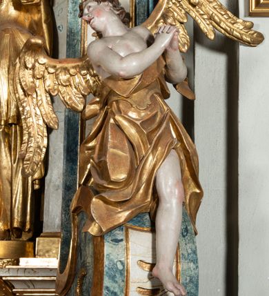 Zdjęcie nr 34: Ołtarz architektoniczny, jednoosiowy, jednokondygnacyjny ze zwieńczeniem, na cokole. Mensa drewniana umieszczona na drewnianej tumbie o wklęsło-wypukłych bokach. Antependium dekorowane rocaille’owym kartuszem z rytym gorejącym sercem, brzegi zdobione rocaille’em. W predelli przeszklona trumienka z figurą św. Jana Nepomucena, w profilowanej, złoconej ramie, na rocaillowej podstawie. Nastawa ujęta parami występujących do przodu filarów: wewnętrzne filary opięte pilastrami; zewnętrzne filary z wolutami zamiast trzonów, z figurami aniołów. Podpory dźwigają pełne belkowanie, przerwane nad polem środkowym. W polu nisza w kształcie stojącego prostokąta zamkniętego trójbocznie, w której obraz Święta Rodzina w profilowanej ramie. Przy filarach od wewnątrz rocaille’owe konsole z figurami św. Doroty i św. Katarzyny Aleksandryjskiej. Zwieńczenie w formie aedikuli zbliżonej do kwadratu o fantazyjnym wklęsło-wypukłym zamknięciu; ujęte pilastrami przechodzącymi w spływy wolutowe, opadające na belkowanie, tworzące postumenty dla figur św. Stefana i św. Emeryka. W polu zwieńczenia obraz z przedstawieniem Świętej Rodziny przy pracy, w kształcie kwadratu o wklęsłych narożach, w profilowanej ramie. Zwieńczenie zamknięte glorią promienistą z literami IHS w otoczeniu obłoków; na osi pilastrów rokokowe wazony z różami.W partii cokołów kanony w rocaille’owych ramach. Trzony pilastrów i woluty dekorowane rocaille’owymi płycinami, we fryzie rocaille. Nisza w polu środkowym ujęta rocaille’ami, zwieńczona mitrą książęcą, flankowana przez parę uskrzydlonych główek anielskich. Woluty zwieńczenia dekorowane motywami rocaille’ów. Rama obrazu w polu ujęta małżowiną, ornamentem roślinnym i rocaille’ami. Struktura marmoryzowana w odcieniu jasnoniebieskim, podpory, tumba i cokoły w odcieniu kości słoniowej; ornamentyka i profile złocone.