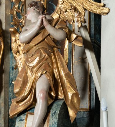 Zdjęcie nr 33: Ołtarz architektoniczny, jednoosiowy, jednokondygnacyjny ze zwieńczeniem, na cokole. Mensa drewniana umieszczona na drewnianej tumbie o wklęsło-wypukłych bokach. Antependium dekorowane rocaille’owym kartuszem z rytym gorejącym sercem, brzegi zdobione rocaille’em. W predelli przeszklona trumienka z figurą św. Jana Nepomucena, w profilowanej, złoconej ramie, na rocaillowej podstawie. Nastawa ujęta parami występujących do przodu filarów: wewnętrzne filary opięte pilastrami; zewnętrzne filary z wolutami zamiast trzonów, z figurami aniołów. Podpory dźwigają pełne belkowanie, przerwane nad polem środkowym. W polu nisza w kształcie stojącego prostokąta zamkniętego trójbocznie, w której obraz Święta Rodzina w profilowanej ramie. Przy filarach od wewnątrz rocaille’owe konsole z figurami św. Doroty i św. Katarzyny Aleksandryjskiej. Zwieńczenie w formie aedikuli zbliżonej do kwadratu o fantazyjnym wklęsło-wypukłym zamknięciu; ujęte pilastrami przechodzącymi w spływy wolutowe, opadające na belkowanie, tworzące postumenty dla figur św. Stefana i św. Emeryka. W polu zwieńczenia obraz z przedstawieniem Świętej Rodziny przy pracy, w kształcie kwadratu o wklęsłych narożach, w profilowanej ramie. Zwieńczenie zamknięte glorią promienistą z literami IHS w otoczeniu obłoków; na osi pilastrów rokokowe wazony z różami.W partii cokołów kanony w rocaille’owych ramach. Trzony pilastrów i woluty dekorowane rocaille’owymi płycinami, we fryzie rocaille. Nisza w polu środkowym ujęta rocaille’ami, zwieńczona mitrą książęcą, flankowana przez parę uskrzydlonych główek anielskich. Woluty zwieńczenia dekorowane motywami rocaille’ów. Rama obrazu w polu ujęta małżowiną, ornamentem roślinnym i rocaille’ami. Struktura marmoryzowana w odcieniu jasnoniebieskim, podpory, tumba i cokoły w odcieniu kości słoniowej; ornamentyka i profile złocone.