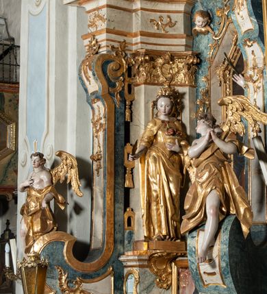 Zdjęcie nr 14: Ołtarz architektoniczny, jednoosiowy, jednokondygnacyjny ze zwieńczeniem, na cokole. Mensa drewniana umieszczona na drewnianej tumbie o wklęsło-wypukłych bokach. Antependium dekorowane rocaille’owym kartuszem z rytym gorejącym sercem, brzegi zdobione rocaille’em. W predelli przeszklona trumienka z figurą św. Jana Nepomucena, w profilowanej, złoconej ramie, na rocaillowej podstawie. Nastawa ujęta parami występujących do przodu filarów: wewnętrzne filary opięte pilastrami; zewnętrzne filary z wolutami zamiast trzonów, z figurami aniołów. Podpory dźwigają pełne belkowanie, przerwane nad polem środkowym. W polu nisza w kształcie stojącego prostokąta zamkniętego trójbocznie, w której obraz Święta Rodzina w profilowanej ramie. Przy filarach od wewnątrz rocaille’owe konsole z figurami św. Doroty i św. Katarzyny Aleksandryjskiej. Zwieńczenie w formie aedikuli zbliżonej do kwadratu o fantazyjnym wklęsło-wypukłym zamknięciu; ujęte pilastrami przechodzącymi w spływy wolutowe, opadające na belkowanie, tworzące postumenty dla figur św. Stefana i św. Emeryka. W polu zwieńczenia obraz z przedstawieniem Świętej Rodziny przy pracy, w kształcie kwadratu o wklęsłych narożach, w profilowanej ramie. Zwieńczenie zamknięte glorią promienistą z literami IHS w otoczeniu obłoków; na osi pilastrów rokokowe wazony z różami.W partii cokołów kanony w rocaille’owych ramach. Trzony pilastrów i woluty dekorowane rocaille’owymi płycinami, we fryzie rocaille. Nisza w polu środkowym ujęta rocaille’ami, zwieńczona mitrą książęcą, flankowana przez parę uskrzydlonych główek anielskich. Woluty zwieńczenia dekorowane motywami rocaille’ów. Rama obrazu w polu ujęta małżowiną, ornamentem roślinnym i rocaille’ami. Struktura marmoryzowana w odcieniu jasnoniebieskim, podpory, tumba i cokoły w odcieniu kości słoniowej; ornamentyka i profile złocone.