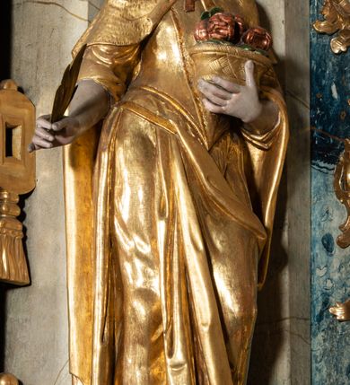 Zdjęcie nr 27: Ołtarz architektoniczny, jednoosiowy, jednokondygnacyjny ze zwieńczeniem, na cokole. Mensa drewniana umieszczona na drewnianej tumbie o wklęsło-wypukłych bokach. Antependium dekorowane rocaille’owym kartuszem z rytym gorejącym sercem, brzegi zdobione rocaille’em. W predelli przeszklona trumienka z figurą św. Jana Nepomucena, w profilowanej, złoconej ramie, na rocaillowej podstawie. Nastawa ujęta parami występujących do przodu filarów: wewnętrzne filary opięte pilastrami; zewnętrzne filary z wolutami zamiast trzonów, z figurami aniołów. Podpory dźwigają pełne belkowanie, przerwane nad polem środkowym. W polu nisza w kształcie stojącego prostokąta zamkniętego trójbocznie, w której obraz Święta Rodzina w profilowanej ramie. Przy filarach od wewnątrz rocaille’owe konsole z figurami św. Doroty i św. Katarzyny Aleksandryjskiej. Zwieńczenie w formie aedikuli zbliżonej do kwadratu o fantazyjnym wklęsło-wypukłym zamknięciu; ujęte pilastrami przechodzącymi w spływy wolutowe, opadające na belkowanie, tworzące postumenty dla figur św. Stefana i św. Emeryka. W polu zwieńczenia obraz z przedstawieniem Świętej Rodziny przy pracy, w kształcie kwadratu o wklęsłych narożach, w profilowanej ramie. Zwieńczenie zamknięte glorią promienistą z literami IHS w otoczeniu obłoków; na osi pilastrów rokokowe wazony z różami.W partii cokołów kanony w rocaille’owych ramach. Trzony pilastrów i woluty dekorowane rocaille’owymi płycinami, we fryzie rocaille. Nisza w polu środkowym ujęta rocaille’ami, zwieńczona mitrą książęcą, flankowana przez parę uskrzydlonych główek anielskich. Woluty zwieńczenia dekorowane motywami rocaille’ów. Rama obrazu w polu ujęta małżowiną, ornamentem roślinnym i rocaille’ami. Struktura marmoryzowana w odcieniu jasnoniebieskim, podpory, tumba i cokoły w odcieniu kości słoniowej; ornamentyka i profile złocone.