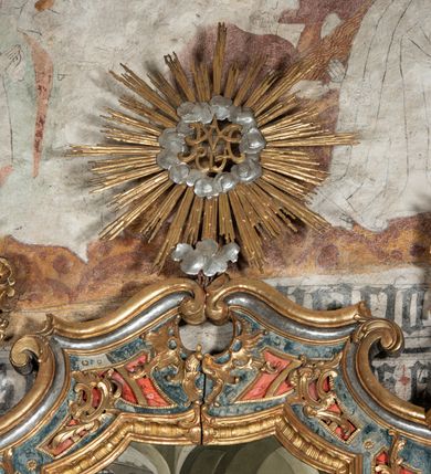 Zdjęcie nr 37: Ołtarz architektoniczny, jednoosiowy, jednokondygnacyjny ze zwieńczeniem, na cokole. Mensa drewniana umieszczona na drewnianej tumbie o wklęsło-wypukłych bokach. Antependium dekorowane rocaille’owym kartuszem z rytym gorejącym sercem, brzegi zdobione rocaille’em. W predelli przeszklona trumienka z figurą św. Jana Nepomucena, w profilowanej, złoconej ramie, na rocaillowej podstawie. Nastawa ujęta parami występujących do przodu filarów: wewnętrzne filary opięte pilastrami; zewnętrzne filary z wolutami zamiast trzonów, z figurami aniołów. Podpory dźwigają pełne belkowanie, przerwane nad polem środkowym. W polu nisza w kształcie stojącego prostokąta zamkniętego trójbocznie, w której obraz Święta Rodzina w profilowanej ramie. Przy filarach od wewnątrz rocaille’owe konsole z figurami św. Doroty i św. Katarzyny Aleksandryjskiej. Zwieńczenie w formie aedikuli zbliżonej do kwadratu o fantazyjnym wklęsło-wypukłym zamknięciu; ujęte pilastrami przechodzącymi w spływy wolutowe, opadające na belkowanie, tworzące postumenty dla figur św. Stefana i św. Emeryka. W polu zwieńczenia obraz z przedstawieniem Świętej Rodziny przy pracy, w kształcie kwadratu o wklęsłych narożach, w profilowanej ramie. Zwieńczenie zamknięte glorią promienistą z literami IHS w otoczeniu obłoków; na osi pilastrów rokokowe wazony z różami.W partii cokołów kanony w rocaille’owych ramach. Trzony pilastrów i woluty dekorowane rocaille’owymi płycinami, we fryzie rocaille. Nisza w polu środkowym ujęta rocaille’ami, zwieńczona mitrą książęcą, flankowana przez parę uskrzydlonych główek anielskich. Woluty zwieńczenia dekorowane motywami rocaille’ów. Rama obrazu w polu ujęta małżowiną, ornamentem roślinnym i rocaille’ami. Struktura marmoryzowana w odcieniu jasnoniebieskim, podpory, tumba i cokoły w odcieniu kości słoniowej; ornamentyka i profile złocone.