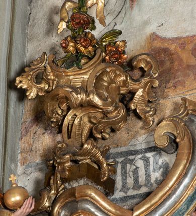 Zdjęcie nr 39: Ołtarz architektoniczny, jednoosiowy, jednokondygnacyjny ze zwieńczeniem, na cokole. Mensa drewniana umieszczona na drewnianej tumbie o wklęsło-wypukłych bokach. Antependium dekorowane rocaille’owym kartuszem z rytym gorejącym sercem, brzegi zdobione rocaille’em. W predelli przeszklona trumienka z figurą św. Jana Nepomucena, w profilowanej, złoconej ramie, na rocaillowej podstawie. Nastawa ujęta parami występujących do przodu filarów: wewnętrzne filary opięte pilastrami; zewnętrzne filary z wolutami zamiast trzonów, z figurami aniołów. Podpory dźwigają pełne belkowanie, przerwane nad polem środkowym. W polu nisza w kształcie stojącego prostokąta zamkniętego trójbocznie, w której obraz Święta Rodzina w profilowanej ramie. Przy filarach od wewnątrz rocaille’owe konsole z figurami św. Doroty i św. Katarzyny Aleksandryjskiej. Zwieńczenie w formie aedikuli zbliżonej do kwadratu o fantazyjnym wklęsło-wypukłym zamknięciu; ujęte pilastrami przechodzącymi w spływy wolutowe, opadające na belkowanie, tworzące postumenty dla figur św. Stefana i św. Emeryka. W polu zwieńczenia obraz z przedstawieniem Świętej Rodziny przy pracy, w kształcie kwadratu o wklęsłych narożach, w profilowanej ramie. Zwieńczenie zamknięte glorią promienistą z literami IHS w otoczeniu obłoków; na osi pilastrów rokokowe wazony z różami.W partii cokołów kanony w rocaille’owych ramach. Trzony pilastrów i woluty dekorowane rocaille’owymi płycinami, we fryzie rocaille. Nisza w polu środkowym ujęta rocaille’ami, zwieńczona mitrą książęcą, flankowana przez parę uskrzydlonych główek anielskich. Woluty zwieńczenia dekorowane motywami rocaille’ów. Rama obrazu w polu ujęta małżowiną, ornamentem roślinnym i rocaille’ami. Struktura marmoryzowana w odcieniu jasnoniebieskim, podpory, tumba i cokoły w odcieniu kości słoniowej; ornamentyka i profile złocone.