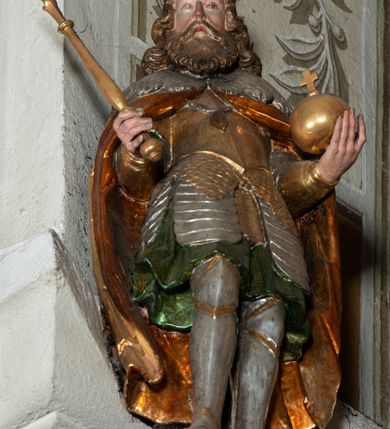 Zdjęcie nr 41: Ołtarz architektoniczny, jednoosiowy, jednokondygnacyjny ze zwieńczeniem, na cokole. Mensa drewniana umieszczona na drewnianej tumbie o wklęsło-wypukłych bokach. Antependium dekorowane rocaille’owym kartuszem z rytym gorejącym sercem, brzegi zdobione rocaille’em. W predelli przeszklona trumienka z figurą św. Jana Nepomucena, w profilowanej, złoconej ramie, na rocaillowej podstawie. Nastawa ujęta parami występujących do przodu filarów: wewnętrzne filary opięte pilastrami; zewnętrzne filary z wolutami zamiast trzonów, z figurami aniołów. Podpory dźwigają pełne belkowanie, przerwane nad polem środkowym. W polu nisza w kształcie stojącego prostokąta zamkniętego trójbocznie, w której obraz Święta Rodzina w profilowanej ramie. Przy filarach od wewnątrz rocaille’owe konsole z figurami św. Doroty i św. Katarzyny Aleksandryjskiej. Zwieńczenie w formie aedikuli zbliżonej do kwadratu o fantazyjnym wklęsło-wypukłym zamknięciu; ujęte pilastrami przechodzącymi w spływy wolutowe, opadające na belkowanie, tworzące postumenty dla figur św. Stefana i św. Emeryka. W polu zwieńczenia obraz z przedstawieniem Świętej Rodziny przy pracy, w kształcie kwadratu o wklęsłych narożach, w profilowanej ramie. Zwieńczenie zamknięte glorią promienistą z literami IHS w otoczeniu obłoków; na osi pilastrów rokokowe wazony z różami.W partii cokołów kanony w rocaille’owych ramach. Trzony pilastrów i woluty dekorowane rocaille’owymi płycinami, we fryzie rocaille. Nisza w polu środkowym ujęta rocaille’ami, zwieńczona mitrą książęcą, flankowana przez parę uskrzydlonych główek anielskich. Woluty zwieńczenia dekorowane motywami rocaille’ów. Rama obrazu w polu ujęta małżowiną, ornamentem roślinnym i rocaille’ami. Struktura marmoryzowana w odcieniu jasnoniebieskim, podpory, tumba i cokoły w odcieniu kości słoniowej; ornamentyka i profile złocone.