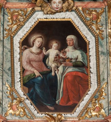 Zdjęcie nr 12: Ołtarz architektoniczny, trójosiowy, z wydzieloną częścią cokołową z bramkami bocznymi, jednokondygnacyjny, ze zwieńczeniem. Mensa drewniana z portatylem z marmuru dębnickiego, umieszczona na drewnianej, prostopadłościennej skrzyni.  Antepedium w kształcie leżącego prostokąta, ujęte profilowaną ramą dekorowaną liśćmi akantu i perełkowaniem. W polu płaskorzeźbione przedstawienie baranka leżącego na krzyżu, na obłoku, ujęte parą liści akantu oraz wicią roślinną z kwiatami i kiściami winogron. 
Na mensie tabernakulum z Tronem Łaski w formie prostopadłościanu na cokole, o wypukłej ściance frontowej, ujęte spływami wolutowymi podtrzymującymi niepełne belkowanie, wyłamane po środku łukiem półkolistym. Na froncie obrotowa nisza ujęta obramieniem w kształcie stojącego prostokąta zamkniętego łukiem nadwieszonym. W niszy ryte przedstawienie kielicha z Eucharystią w glorii, na obłoku, całość w rocaillowej ramie. Powyżej tron wystawienia z cokołem dekorowanym rocaille’em i parą ornamentalnych świeczników; ujęty parą kolumn dźwigających imposty. Podpory dżwigają rocaillowe kabłąki tworzące baldachim, na którego szczycie figurka baranka eucharystycznego leżącego na księdze. Ścianka w formie zbliżonej do stojącego prostokąta ujęta rocaille. Tabernakulum i tron ujęte okazałymi spływami wolutowymi z rocaillowymi uszami oraz na zakończeniach u dołu dwiema rzeźbami klęczących, adorujących aniołów.
Osie nastawy wydzielone w osiach skrajnych parą kolumn o skręconych trzonach i korynckich kapitelach umieszczonych na tle pilastrów, w osiach wewnętrznych parą pilastrów o trzonach w formie wolut z puttami z puttami, podtrzymywaną przez kariatydy w formie okazałych figur uskrzydlonych aniołów. Podpory wspierają pełne belkowanie z profilowanym gzymsem, występujące nad nimi, przerwane nad polem środkowym. W polu środkowym nisza ze sklepieniem kolebkowym wspartym na dwóch filarach i pilastrach. W głębi niszy obraz Św. Bartłomiej w profilowanej ramie w kształcie stojącego prostokąta zamkniętego łukiem odcinkowym. Na podniebiu niszy obraz Męczeństwo św. Bartłomieja w kształcie leżącego prostokąta ujętego niesymetrycznym obramieniem z motywem rocaille’ów. Nisza flankowana z figurami św. Stefana i św. Emeryka umieszczonymi na konsolach, na tle pilastrów. Pola retabulum w osiach skrajnych wklęsłe, między podporami prześwity z figurami św. Piotra i św. Pawła. W partii wysokiego cokołu bramki ujęte od zewnątrz wklęsłymi filarami podtrzymującymi belkowanie, wejścia z drzwiczkami w kształcie stojącego prostokąta zamkniętego łukiem półkolistym z obrazami przedstawiającymi Mojżesza i Aarona. Zwieńczenie w formie aedikuli ujętej pilastrami wspierającymi przerwane belkowanie oraz fantazyjnymi spływami wolutowymi, spływającymi na wewnętrzne podpory, przyjmując formę przerwanego przyczółka, na którym dwa putta i dwie figury siedzących aniołów. W osiach zewnętrznych podpór dwa putta siedzące kanelowanych postumentach i obłokach, prawe przytrzymuje skórę (atrybut św. Bartłomieja). W polu zwieńczenia obraz Św. Anna Samotrzeć w kształcie wydłużonego ośmioboku, w ornamentalnej ramie. Całość zwieńczona rzeźbioną półpostacią Boga Ojca pośród obłoków ukazanego w glorii promienistej. Drzwi do bramek flankowane liściastymi festonami, powyżej tarcze ujęte liśćmi laurowymi, zwieńczone koroną z klejnotem; lewa z klejnotem w postaci łabędzia z napisem: SOLI/ DEO/GLORIA, prawa z postacią ludzką z napisem: SOLI DEO HONOR. Woluty i fryz dekorowane motywami rocaille’ów oraz uskrzydlonymi główkami anielskimi. Osie boczne wypełnione ażurowymi rocaille’ami z gałązkami różanymi oraz ornamentem małżowinowo-chrząstkowym, belkowanie z podwieszonym lambrekinem z chwostami. Skręcone trzony kolumn zdobione wicią z winnej latorośli. Archiwolta nad polem środkowym dekorowana rocaille’em, rocaille’owym kartuszem i lambrekinem z chwostami. Woluty zwieńczenia, pilastry i naroża pola obrazowego dekorowane motywami rocaille’ów. 
Nastawa marmoryzowana w odcieniu jasnoszarym, profile marmoryzowane w kolorze jasnoróżowym, ornamenty i obramienia złocone.