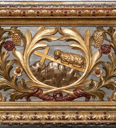 Zdjęcie nr 4: Ołtarz architektoniczny, trójosiowy, z wydzieloną częścią cokołową z bramkami bocznymi, jednokondygnacyjny, ze zwieńczeniem. Mensa drewniana z portatylem z marmuru dębnickiego, umieszczona na drewnianej, prostopadłościennej skrzyni.  Antepedium w kształcie leżącego prostokąta, ujęte profilowaną ramą dekorowaną liśćmi akantu i perełkowaniem. W polu płaskorzeźbione przedstawienie baranka leżącego na krzyżu, na obłoku, ujęte parą liści akantu oraz wicią roślinną z kwiatami i kiściami winogron. 
Na mensie tabernakulum z Tronem Łaski w formie prostopadłościanu na cokole, o wypukłej ściance frontowej, ujęte spływami wolutowymi podtrzymującymi niepełne belkowanie, wyłamane po środku łukiem półkolistym. Na froncie obrotowa nisza ujęta obramieniem w kształcie stojącego prostokąta zamkniętego łukiem nadwieszonym. W niszy ryte przedstawienie kielicha z Eucharystią w glorii, na obłoku, całość w rocaillowej ramie. Powyżej tron wystawienia z cokołem dekorowanym rocaille’em i parą ornamentalnych świeczników; ujęty parą kolumn dźwigających imposty. Podpory dżwigają rocaillowe kabłąki tworzące baldachim, na którego szczycie figurka baranka eucharystycznego leżącego na księdze. Ścianka w formie zbliżonej do stojącego prostokąta ujęta rocaille. Tabernakulum i tron ujęte okazałymi spływami wolutowymi z rocaillowymi uszami oraz na zakończeniach u dołu dwiema rzeźbami klęczących, adorujących aniołów.
Osie nastawy wydzielone w osiach skrajnych parą kolumn o skręconych trzonach i korynckich kapitelach umieszczonych na tle pilastrów, w osiach wewnętrznych parą pilastrów o trzonach w formie wolut z puttami z puttami, podtrzymywaną przez kariatydy w formie okazałych figur uskrzydlonych aniołów. Podpory wspierają pełne belkowanie z profilowanym gzymsem, występujące nad nimi, przerwane nad polem środkowym. W polu środkowym nisza ze sklepieniem kolebkowym wspartym na dwóch filarach i pilastrach. W głębi niszy obraz Św. Bartłomiej w profilowanej ramie w kształcie stojącego prostokąta zamkniętego łukiem odcinkowym. Na podniebiu niszy obraz Męczeństwo św. Bartłomieja w kształcie leżącego prostokąta ujętego niesymetrycznym obramieniem z motywem rocaille’ów. Nisza flankowana z figurami św. Stefana i św. Emeryka umieszczonymi na konsolach, na tle pilastrów. Pola retabulum w osiach skrajnych wklęsłe, między podporami prześwity z figurami św. Piotra i św. Pawła. W partii wysokiego cokołu bramki ujęte od zewnątrz wklęsłymi filarami podtrzymującymi belkowanie, wejścia z drzwiczkami w kształcie stojącego prostokąta zamkniętego łukiem półkolistym z obrazami przedstawiającymi Mojżesza i Aarona. Zwieńczenie w formie aedikuli ujętej pilastrami wspierającymi przerwane belkowanie oraz fantazyjnymi spływami wolutowymi, spływającymi na wewnętrzne podpory, przyjmując formę przerwanego przyczółka, na którym dwa putta i dwie figury siedzących aniołów. W osiach zewnętrznych podpór dwa putta siedzące kanelowanych postumentach i obłokach, prawe przytrzymuje skórę (atrybut św. Bartłomieja). W polu zwieńczenia obraz Św. Anna Samotrzeć w kształcie wydłużonego ośmioboku, w ornamentalnej ramie. Całość zwieńczona rzeźbioną półpostacią Boga Ojca pośród obłoków ukazanego w glorii promienistej. Drzwi do bramek flankowane liściastymi festonami, powyżej tarcze ujęte liśćmi laurowymi, zwieńczone koroną z klejnotem; lewa z klejnotem w postaci łabędzia z napisem: SOLI/ DEO/GLORIA, prawa z postacią ludzką z napisem: SOLI DEO HONOR. Woluty i fryz dekorowane motywami rocaille’ów oraz uskrzydlonymi główkami anielskimi. Osie boczne wypełnione ażurowymi rocaille’ami z gałązkami różanymi oraz ornamentem małżowinowo-chrząstkowym, belkowanie z podwieszonym lambrekinem z chwostami. Skręcone trzony kolumn zdobione wicią z winnej latorośli. Archiwolta nad polem środkowym dekorowana rocaille’em, rocaille’owym kartuszem i lambrekinem z chwostami. Woluty zwieńczenia, pilastry i naroża pola obrazowego dekorowane motywami rocaille’ów. 
Nastawa marmoryzowana w odcieniu jasnoszarym, profile marmoryzowane w kolorze jasnoróżowym, ornamenty i obramienia złocone.