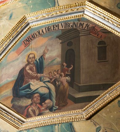 Zdjęcie nr 4: Prospekt architektoniczny, pięcioosiowy, na cokole. Oś środkowa i skrajne wyznaczone ryzalitami. Ryzalit środkowy wyższy od skrajnych, wieloboczny, ryzality skrajne dwuboczne (kątowe); we wszystkich osiach prześwity wypełnione piszczałkami; zwieńczone belkowaniem, podtrzymywane przez wsporniki. Prospekt ujęty uszami utworzonymi z motywów suchego akantu i karbowanej wstęgi. W zwieńczeniu ryzalitu środkowego osiem kabłąków dekorowanych perełkowaniem podtrzymujących rzeźbionego ptaka (kukułka). Ryzality zewnętrzne zwieńczone ażurowymi, trójkątnymi szczytami utworzonymi z motywów roślinnych. Pomiędzy ryzalitami oraz w górnych częściach prześwitów ornament małżowinowy, w dolnej fryz palmetowy. Struktura marmoryzowana na niebiesko, profile i gzyms na czerwono, ornamentyka złocona. Parapet chóru muzycznego, z wypukłą, półokrągłą częścią środkową, wspartą parze filarów stojących na wysokich graniastosłupowych cokołach, o kanelowanych trzonach i akantowych kapitelach, podzielony na siedem pól wydzielonych korynckimi kolumienkami, o gładkich, srebrzonych trzonach, złoconych bazach o kapitelach, stojącymi na konsolkach z podwieszeniem w kształcie szyszki. Kolumienki wspierają wyłamujący się nad nimi gzyms parapetu. Pola w kształcie leżącego prostokąta, ujęte fantazyjnie ukształtowanymi fartuchami, zdobione na przemian obrazami w kształcie ośmioboku lub leżącego owalu opisanego na kwadracie. Obrazy ujęte dekoracyjnymi, profilowanymi ramami. W górnej partii każdego przedstawienia wstęga z napisem: (od lewej): PARABOLA DE PARANDIS PRO TURI ET BELLO Sublibus. Luc. 14 V 2: PARABOLA EPULONIS ET LAZARI Luc. 16 V. 19; PARABOLA PHARISAEI ET PUBLICANI Luc. 18. V. 9; W polu środkowym mały trójosiowy pozytyw. PARABOLA DECEM VIRGINUM MATTH. 23. V. 1; CHRISTUS TRANSFIGURATUR MATTH. 17. V. 1; PROHIBET NIMIAM PROVICTU CURAM MATTH. 6. 25. Struktura marmoryzowana w odcieniach zieleni, beżów i czerwieni; ornamentyka i detal architektoniczny złocony i srebrzony. 