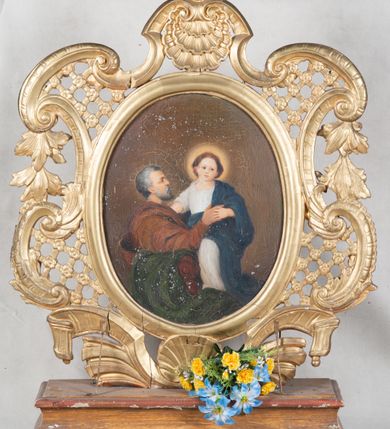 Zdjęcie nr 2: Feretron dwustronny ustawiony na prostopadłościennej podstawie zaopatrzonej w otwory na drążki do noszenia. Struktura feretronu od dołu flankowana dwiema wstęgami zdobionymi puklowaniem, spiętymi pośrodku muszlą palmetową. Boki utworzone z ażurowej kratki ujętej wolutami i ze spływającymi kampanulami. W zwieńczeniu muszla palmetowa i rocaille wraz z zatkniętym u szczytu akroterionem. W polu w owalnej, profilowanej i złoconej ramie obrazy: „Św. Anna Samotrzeć” oraz „Św. Joachim z małą Marią”. Na obrazie św. Anny Samotrzeć ukazana Matka Boska po lewej stronie, św. Anna po prawej, na kolanach Marii Dzieciątko Jezus, a nad nimi gołębica Ducha Świętego. Obie kobiety ukazane w pozycji siedzącej, zwrócone w trzech czwartych ku środkowi, rękami przytrzymujące Dzieciątko. Twarz Marii o delikatnych rysach, z prostym nosem, dużymi i brązowymi oczami oraz o wyraźnych ustach. Jej jasnobrązowe włosy są częściowo schowane pod białym welonem ze złotą lamówką. Ubrana jest w czerwoną suknię oraz niebieski płaszcz założony na lewe ramię i zasłaniający kolana. Po drugiej stronie św. Anna o twarzy cechującej się rysami starszej kobiety z włosami schowanymi całkowicie pod białym welonem ze złotą opaską wokół głowy. Ubrana jest w zieloną suknię oraz czerwony płaszcz założony na kolana. Dzieciątko Jezus zwrócone trzy czwarte w lewo, z głową skierowaną w drugą stronę, z lewą nóżką wysuniętą do przodu, w dłoniach trzymające niebieskie jabłko królewskie. Twarz o dziecięcych rysach z zarumienionymi policzkami, okolona kędzierzawymi włosami. Ubrany jest w zwiewną pieluszkę odsłaniającą ramiona, którą z jednego końca podtrzymuje Matka Boska. Nad głową Marii i św. Anny złote, koliste nimby, a wokół głowy Dzieciątka nimb krzyżowy. Tło w różnych odcieniach brązu. Po drugiej stronie feretronu obraz św. Joachima z małą Marią. W centrum kompozycji św. Joachim siedzący w fotelu i trzymający na kolanach małą Marię. Matka Boska ukazana w postawie stojącej, rękami trzymająca się św. Joachima. Twarz o rysach dziecka, z małymi ustami i nosem oraz dużymi oczami. Włosy bujne, ciemnobrązowe, upięte do tyłu, wokół głowy świetlisty nimb. Ubrana jest w białą suknię oraz ciemnoniebieski płaszcz założony na lewe ramię. Święty Joachim widoczny z prawego profilu, prawą ręką ujmujący Marię. Twarz podłużna, okolona siwą brodą oraz siwymi włosami. Ubrany jest w brązową suknię z długimi rękawami oraz zielony płaszcz przewieszony przez poręcz krzesła. Tło jednolite, brązowe. 


