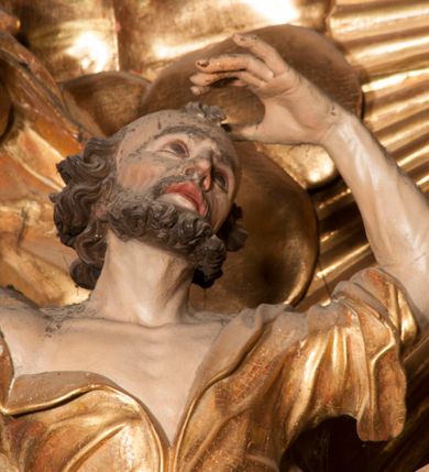 Zdjęcie nr 51: Nastawa jednoosiowa, jednokondygnacyjna ze zwieńczeniem, na wysokim dwustrefowym cokole z wyodrębnionymi czterema prostopadłościanami. Ołtarz kamienny, prostopadłościenny, z kamienną mensą. Antepedium ujęte srebrzoną opaską z napisem „kości ich niech wypuszczą pędu ze swego miejsca, aby byli wsławieni przez swoich synów”, pole podzielone na cztery części ornamentem roślinnym, każda wypełniona złoconą wicią kwiatową i czterema okrągłymi prześwitami. Na ołtarzu ustawione tabernakulum w formie Arki Przymierza. Nastawa ujęta dwiema parami pilastrów i dwiema parami kolumn o kręconych trzonach ustawionych pod kątem na zewnątrz, dźwigającymi pełne belkowanie z kostkowaniem, wyłamane na ich osi, przerwane nad polem środkowym oraz fragmenty przerwanego, półkolistego przyczółka. W polu środkowym wnęka w formie stojącego prostokąta zamkniętego łukiem półkolistym, w niej mniejszy obraz w kształcie stojącego prostokąta zamkniętego łukiem półkolistym nadwieszonym z przedstawieniem Wizji św. Franciszka, ujęty ramą dekorowaną rocaille'em. Zwieńczenie w formie grupy rzeźbiarskiej Przemienienia Pańskiego na tle obłoków i w glorii promienistej. 
W partii belkowania nad polem głównym, na rzeźbionej skale podtrzymywanej przez rocaille klęczące postacie św. Piotra, św. Jana i św. Jakuba w dynamicznych pozach. Nad nimi unosi się Chrystus w otoku z obłoków i glorii, flankowany przez figury Mojżesza i Eliasza klęczące na przerwanym przyczółku, za nimi nadlatujące putta na obłokach. Po lewej stronie Piotr klęczący frontalnie z uniesionymi rękami. Obok niego klęczący św. Jan zwrócony profilem w lewo, z rękami wyciągniętymi w przód, o młodzieńczych rysach i długich, kręconych włosach. Święty Jakub po prawej stronie, w pozycji siedzącej, zwrócony w trzech czwartych w prawo z rękami wyciągniętymi w lewo. Wszyscy ubrani w przylegające do ciała tuniki oraz płaszcze przepasane w partii nóg. Nad nimi Chrystus w pozycji stojącej, frontalnie, w kontrapoście, z uniesioną głową i rękami rozłożonymi na boki, ubrany jest w tunikę oraz płaszcz przewiązany przez lewe ramię i wokół nóg. Na lewym fragmencie przyczółka klęczy Eliasz, zwrócony w trzech czwartych w lewo, pochylony, prawą ręką przytrzymuje na boku księgę, lewą wyciąga w przód. Ubrany jest w tunikę oraz rozwiany płaszcz. Na prawym fragmencie przyczółka klęczy Mojżesz, zwrócony w trzech czwartych w prawo, z pochylona głową, obiema rękami trzyma tablice przykazań. Ubrany jest w tunikę o krótkich rękawach oraz płaszcz zawinięty na lewym ramieniu i opadający na nogi. Obaj prorocy ukazani jako starcy. Nastawa flankowana dwoma wspornikami z figurami św. Wacława i św. Floriana. Struktura polichromowana w kolorze beżowym z żółtymi detalami oraz złoconymi profilami, ornamentyką i zwieńczeniem. Figury w partii ciała polichromowane naturalistycznie z brązowymi włosami i brodami oraz złoconymi szatami i atrybutami. 

