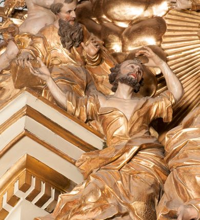 Zdjęcie nr 53: Nastawa jednoosiowa, jednokondygnacyjna ze zwieńczeniem, na wysokim dwustrefowym cokole z wyodrębnionymi czterema prostopadłościanami. Ołtarz kamienny, prostopadłościenny, z kamienną mensą. Antepedium ujęte srebrzoną opaską z napisem „kości ich niech wypuszczą pędu ze swego miejsca, aby byli wsławieni przez swoich synów”, pole podzielone na cztery części ornamentem roślinnym, każda wypełniona złoconą wicią kwiatową i czterema okrągłymi prześwitami. Na ołtarzu ustawione tabernakulum w formie Arki Przymierza. Nastawa ujęta dwiema parami pilastrów i dwiema parami kolumn o kręconych trzonach ustawionych pod kątem na zewnątrz, dźwigającymi pełne belkowanie z kostkowaniem, wyłamane na ich osi, przerwane nad polem środkowym oraz fragmenty przerwanego, półkolistego przyczółka. W polu środkowym wnęka w formie stojącego prostokąta zamkniętego łukiem półkolistym, w niej mniejszy obraz w kształcie stojącego prostokąta zamkniętego łukiem półkolistym nadwieszonym z przedstawieniem Wizji św. Franciszka, ujęty ramą dekorowaną rocaille&#039;em. Zwieńczenie w formie grupy rzeźbiarskiej Przemienienia Pańskiego na tle obłoków i w glorii promienistej. 
W partii belkowania nad polem głównym, na rzeźbionej skale podtrzymywanej przez rocaille klęczące postacie św. Piotra, św. Jana i św. Jakuba w dynamicznych pozach. Nad nimi unosi się Chrystus w otoku z obłoków i glorii, flankowany przez figury Mojżesza i Eliasza klęczące na przerwanym przyczółku, za nimi nadlatujące putta na obłokach. Po lewej stronie Piotr klęczący frontalnie z uniesionymi rękami. Obok niego klęczący św. Jan zwrócony profilem w lewo, z rękami wyciągniętymi w przód, o młodzieńczych rysach i długich, kręconych włosach. Święty Jakub po prawej stronie, w pozycji siedzącej, zwrócony w trzech czwartych w prawo z rękami wyciągniętymi w lewo. Wszyscy ubrani w przylegające do ciała tuniki oraz płaszcze przepasane w partii nóg. Nad nimi Chrystus w pozycji stojącej, frontalnie, w kontrapoście, z uniesioną głową i rękami rozłożonymi na boki, ubrany jest w tunikę oraz płaszcz przewiązany przez lewe ramię i wokół nóg. Na lewym fragmencie przyczółka klęczy Eliasz, zwrócony w trzech czwartych w lewo, pochylony, prawą ręką przytrzymuje na boku księgę, lewą wyciąga w przód. Ubrany jest w tunikę oraz rozwiany płaszcz. Na prawym fragmencie przyczółka klęczy Mojżesz, zwrócony w trzech czwartych w prawo, z pochylona głową, obiema rękami trzyma tablice przykazań. Ubrany jest w tunikę o krótkich rękawach oraz płaszcz zawinięty na lewym ramieniu i opadający na nogi. Obaj prorocy ukazani jako starcy. Nastawa flankowana dwoma wspornikami z figurami św. Wacława i św. Floriana. Struktura polichromowana w kolorze beżowym z żółtymi detalami oraz złoconymi profilami, ornamentyką i zwieńczeniem. Figury w partii ciała polichromowane naturalistycznie z brązowymi włosami i brodami oraz złoconymi szatami i atrybutami. 

