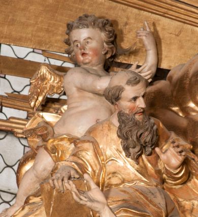 Zdjęcie nr 54: Nastawa jednoosiowa, jednokondygnacyjna ze zwieńczeniem, na wysokim dwustrefowym cokole z wyodrębnionymi czterema prostopadłościanami. Ołtarz kamienny, prostopadłościenny, z kamienną mensą. Antepedium ujęte srebrzoną opaską z napisem „kości ich niech wypuszczą pędu ze swego miejsca, aby byli wsławieni przez swoich synów”, pole podzielone na cztery części ornamentem roślinnym, każda wypełniona złoconą wicią kwiatową i czterema okrągłymi prześwitami. Na ołtarzu ustawione tabernakulum w formie Arki Przymierza. Nastawa ujęta dwiema parami pilastrów i dwiema parami kolumn o kręconych trzonach ustawionych pod kątem na zewnątrz, dźwigającymi pełne belkowanie z kostkowaniem, wyłamane na ich osi, przerwane nad polem środkowym oraz fragmenty przerwanego, półkolistego przyczółka. W polu środkowym wnęka w formie stojącego prostokąta zamkniętego łukiem półkolistym, w niej mniejszy obraz w kształcie stojącego prostokąta zamkniętego łukiem półkolistym nadwieszonym z przedstawieniem Wizji św. Franciszka, ujęty ramą dekorowaną rocaille&#039;em. Zwieńczenie w formie grupy rzeźbiarskiej Przemienienia Pańskiego na tle obłoków i w glorii promienistej. 
W partii belkowania nad polem głównym, na rzeźbionej skale podtrzymywanej przez rocaille klęczące postacie św. Piotra, św. Jana i św. Jakuba w dynamicznych pozach. Nad nimi unosi się Chrystus w otoku z obłoków i glorii, flankowany przez figury Mojżesza i Eliasza klęczące na przerwanym przyczółku, za nimi nadlatujące putta na obłokach. Po lewej stronie Piotr klęczący frontalnie z uniesionymi rękami. Obok niego klęczący św. Jan zwrócony profilem w lewo, z rękami wyciągniętymi w przód, o młodzieńczych rysach i długich, kręconych włosach. Święty Jakub po prawej stronie, w pozycji siedzącej, zwrócony w trzech czwartych w prawo z rękami wyciągniętymi w lewo. Wszyscy ubrani w przylegające do ciała tuniki oraz płaszcze przepasane w partii nóg. Nad nimi Chrystus w pozycji stojącej, frontalnie, w kontrapoście, z uniesioną głową i rękami rozłożonymi na boki, ubrany jest w tunikę oraz płaszcz przewiązany przez lewe ramię i wokół nóg. Na lewym fragmencie przyczółka klęczy Eliasz, zwrócony w trzech czwartych w lewo, pochylony, prawą ręką przytrzymuje na boku księgę, lewą wyciąga w przód. Ubrany jest w tunikę oraz rozwiany płaszcz. Na prawym fragmencie przyczółka klęczy Mojżesz, zwrócony w trzech czwartych w prawo, z pochylona głową, obiema rękami trzyma tablice przykazań. Ubrany jest w tunikę o krótkich rękawach oraz płaszcz zawinięty na lewym ramieniu i opadający na nogi. Obaj prorocy ukazani jako starcy. Nastawa flankowana dwoma wspornikami z figurami św. Wacława i św. Floriana. Struktura polichromowana w kolorze beżowym z żółtymi detalami oraz złoconymi profilami, ornamentyką i zwieńczeniem. Figury w partii ciała polichromowane naturalistycznie z brązowymi włosami i brodami oraz złoconymi szatami i atrybutami. 

