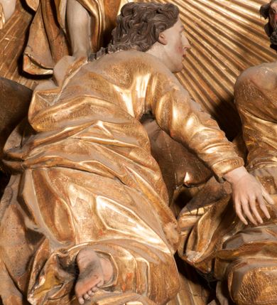 Zdjęcie nr 5: Nastawa jednoosiowa, jednokondygnacyjna ze zwieńczeniem, na wysokim dwustrefowym cokole z wyodrębnionymi czterema prostopadłościanami. Ołtarz kamienny, prostopadłościenny, z kamienną mensą. Antepedium ujęte srebrzoną opaską z napisem „kości ich niech wypuszczą pędu ze swego miejsca, aby byli wsławieni przez swoich synów”, pole podzielone na cztery części ornamentem roślinnym, każda wypełniona złoconą wicią kwiatową i czterema okrągłymi prześwitami. Na ołtarzu ustawione tabernakulum w formie Arki Przymierza. Nastawa ujęta dwiema parami pilastrów i dwiema parami kolumn o kręconych trzonach ustawionych pod kątem na zewnątrz, dźwigającymi pełne belkowanie z kostkowaniem, wyłamane na ich osi, przerwane nad polem środkowym oraz fragmenty przerwanego, półkolistego przyczółka. W polu środkowym wnęka w formie stojącego prostokąta zamkniętego łukiem półkolistym, w niej mniejszy obraz w kształcie stojącego prostokąta zamkniętego łukiem półkolistym nadwieszonym z przedstawieniem Wizji św. Franciszka, ujęty ramą dekorowaną rocaille&#039;em. Zwieńczenie w formie grupy rzeźbiarskiej Przemienienia Pańskiego na tle obłoków i w glorii promienistej. 
W partii belkowania nad polem głównym, na rzeźbionej skale podtrzymywanej przez rocaille klęczące postacie św. Piotra, św. Jana i św. Jakuba w dynamicznych pozach. Nad nimi unosi się Chrystus w otoku z obłoków i glorii, flankowany przez figury Mojżesza i Eliasza klęczące na przerwanym przyczółku, za nimi nadlatujące putta na obłokach. Po lewej stronie Piotr klęczący frontalnie z uniesionymi rękami. Obok niego klęczący św. Jan zwrócony profilem w lewo, z rękami wyciągniętymi w przód, o młodzieńczych rysach i długich, kręconych włosach. Święty Jakub po prawej stronie, w pozycji siedzącej, zwrócony w trzech czwartych w prawo z rękami wyciągniętymi w lewo. Wszyscy ubrani w przylegające do ciała tuniki oraz płaszcze przepasane w partii nóg. Nad nimi Chrystus w pozycji stojącej, frontalnie, w kontrapoście, z uniesioną głową i rękami rozłożonymi na boki, ubrany jest w tunikę oraz płaszcz przewiązany przez lewe ramię i wokół nóg. Na lewym fragmencie przyczółka klęczy Eliasz, zwrócony w trzech czwartych w lewo, pochylony, prawą ręką przytrzymuje na boku księgę, lewą wyciąga w przód. Ubrany jest w tunikę oraz rozwiany płaszcz. Na prawym fragmencie przyczółka klęczy Mojżesz, zwrócony w trzech czwartych w prawo, z pochylona głową, obiema rękami trzyma tablice przykazań. Ubrany jest w tunikę o krótkich rękawach oraz płaszcz zawinięty na lewym ramieniu i opadający na nogi. Obaj prorocy ukazani jako starcy. Nastawa flankowana dwoma wspornikami z figurami św. Wacława i św. Floriana. Struktura polichromowana w kolorze beżowym z żółtymi detalami oraz złoconymi profilami, ornamentyką i zwieńczeniem. Figury w partii ciała polichromowane naturalistycznie z brązowymi włosami i brodami oraz złoconymi szatami i atrybutami. 

