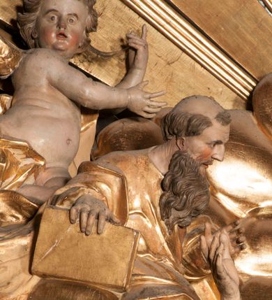 Zdjęcie nr 9: Nastawa jednoosiowa, jednokondygnacyjna ze zwieńczeniem, na wysokim dwustrefowym cokole z wyodrębnionymi czterema prostopadłościanami. Ołtarz kamienny, prostopadłościenny, z kamienną mensą. Antepedium ujęte srebrzoną opaską z napisem „kości ich niech wypuszczą pędu ze swego miejsca, aby byli wsławieni przez swoich synów”, pole podzielone na cztery części ornamentem roślinnym, każda wypełniona złoconą wicią kwiatową i czterema okrągłymi prześwitami. Na ołtarzu ustawione tabernakulum w formie Arki Przymierza. Nastawa ujęta dwiema parami pilastrów i dwiema parami kolumn o kręconych trzonach ustawionych pod kątem na zewnątrz, dźwigającymi pełne belkowanie z kostkowaniem, wyłamane na ich osi, przerwane nad polem środkowym oraz fragmenty przerwanego, półkolistego przyczółka. W polu środkowym wnęka w formie stojącego prostokąta zamkniętego łukiem półkolistym, w niej mniejszy obraz w kształcie stojącego prostokąta zamkniętego łukiem półkolistym nadwieszonym z przedstawieniem Wizji św. Franciszka, ujęty ramą dekorowaną rocaille&#039;em. Zwieńczenie w formie grupy rzeźbiarskiej Przemienienia Pańskiego na tle obłoków i w glorii promienistej. 
W partii belkowania nad polem głównym, na rzeźbionej skale podtrzymywanej przez rocaille klęczące postacie św. Piotra, św. Jana i św. Jakuba w dynamicznych pozach. Nad nimi unosi się Chrystus w otoku z obłoków i glorii, flankowany przez figury Mojżesza i Eliasza klęczące na przerwanym przyczółku, za nimi nadlatujące putta na obłokach. Po lewej stronie Piotr klęczący frontalnie z uniesionymi rękami. Obok niego klęczący św. Jan zwrócony profilem w lewo, z rękami wyciągniętymi w przód, o młodzieńczych rysach i długich, kręconych włosach. Święty Jakub po prawej stronie, w pozycji siedzącej, zwrócony w trzech czwartych w prawo z rękami wyciągniętymi w lewo. Wszyscy ubrani w przylegające do ciała tuniki oraz płaszcze przepasane w partii nóg. Nad nimi Chrystus w pozycji stojącej, frontalnie, w kontrapoście, z uniesioną głową i rękami rozłożonymi na boki, ubrany jest w tunikę oraz płaszcz przewiązany przez lewe ramię i wokół nóg. Na lewym fragmencie przyczółka klęczy Eliasz, zwrócony w trzech czwartych w lewo, pochylony, prawą ręką przytrzymuje na boku księgę, lewą wyciąga w przód. Ubrany jest w tunikę oraz rozwiany płaszcz. Na prawym fragmencie przyczółka klęczy Mojżesz, zwrócony w trzech czwartych w prawo, z pochylona głową, obiema rękami trzyma tablice przykazań. Ubrany jest w tunikę o krótkich rękawach oraz płaszcz zawinięty na lewym ramieniu i opadający na nogi. Obaj prorocy ukazani jako starcy. Nastawa flankowana dwoma wspornikami z figurami św. Wacława i św. Floriana. Struktura polichromowana w kolorze beżowym z żółtymi detalami oraz złoconymi profilami, ornamentyką i zwieńczeniem. Figury w partii ciała polichromowane naturalistycznie z brązowymi włosami i brodami oraz złoconymi szatami i atrybutami. 

