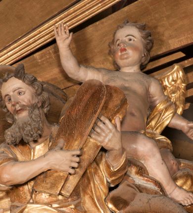 Zdjęcie nr 13: Nastawa jednoosiowa, jednokondygnacyjna ze zwieńczeniem, na wysokim dwustrefowym cokole z wyodrębnionymi czterema prostopadłościanami. Ołtarz kamienny, prostopadłościenny, z kamienną mensą. Antepedium ujęte srebrzoną opaską z napisem „kości ich niech wypuszczą pędu ze swego miejsca, aby byli wsławieni przez swoich synów”, pole podzielone na cztery części ornamentem roślinnym, każda wypełniona złoconą wicią kwiatową i czterema okrągłymi prześwitami. Na ołtarzu ustawione tabernakulum w formie Arki Przymierza. Nastawa ujęta dwiema parami pilastrów i dwiema parami kolumn o kręconych trzonach ustawionych pod kątem na zewnątrz, dźwigającymi pełne belkowanie z kostkowaniem, wyłamane na ich osi, przerwane nad polem środkowym oraz fragmenty przerwanego, półkolistego przyczółka. W polu środkowym wnęka w formie stojącego prostokąta zamkniętego łukiem półkolistym, w niej mniejszy obraz w kształcie stojącego prostokąta zamkniętego łukiem półkolistym nadwieszonym z przedstawieniem Wizji św. Franciszka, ujęty ramą dekorowaną rocaille'em. Zwieńczenie w formie grupy rzeźbiarskiej Przemienienia Pańskiego na tle obłoków i w glorii promienistej. 
W partii belkowania nad polem głównym, na rzeźbionej skale podtrzymywanej przez rocaille klęczące postacie św. Piotra, św. Jana i św. Jakuba w dynamicznych pozach. Nad nimi unosi się Chrystus w otoku z obłoków i glorii, flankowany przez figury Mojżesza i Eliasza klęczące na przerwanym przyczółku, za nimi nadlatujące putta na obłokach. Po lewej stronie Piotr klęczący frontalnie z uniesionymi rękami. Obok niego klęczący św. Jan zwrócony profilem w lewo, z rękami wyciągniętymi w przód, o młodzieńczych rysach i długich, kręconych włosach. Święty Jakub po prawej stronie, w pozycji siedzącej, zwrócony w trzech czwartych w prawo z rękami wyciągniętymi w lewo. Wszyscy ubrani w przylegające do ciała tuniki oraz płaszcze przepasane w partii nóg. Nad nimi Chrystus w pozycji stojącej, frontalnie, w kontrapoście, z uniesioną głową i rękami rozłożonymi na boki, ubrany jest w tunikę oraz płaszcz przewiązany przez lewe ramię i wokół nóg. Na lewym fragmencie przyczółka klęczy Eliasz, zwrócony w trzech czwartych w lewo, pochylony, prawą ręką przytrzymuje na boku księgę, lewą wyciąga w przód. Ubrany jest w tunikę oraz rozwiany płaszcz. Na prawym fragmencie przyczółka klęczy Mojżesz, zwrócony w trzech czwartych w prawo, z pochylona głową, obiema rękami trzyma tablice przykazań. Ubrany jest w tunikę o krótkich rękawach oraz płaszcz zawinięty na lewym ramieniu i opadający na nogi. Obaj prorocy ukazani jako starcy. Nastawa flankowana dwoma wspornikami z figurami św. Wacława i św. Floriana. Struktura polichromowana w kolorze beżowym z żółtymi detalami oraz złoconymi profilami, ornamentyką i zwieńczeniem. Figury w partii ciała polichromowane naturalistycznie z brązowymi włosami i brodami oraz złoconymi szatami i atrybutami. 

