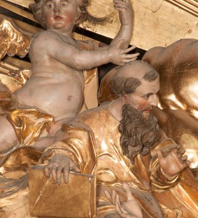 Zdjęcie nr 18: Nastawa jednoosiowa, jednokondygnacyjna ze zwieńczeniem, na wysokim dwustrefowym cokole z wyodrębnionymi czterema prostopadłościanami. Ołtarz kamienny, prostopadłościenny, z kamienną mensą. Antepedium ujęte srebrzoną opaską z napisem „kości ich niech wypuszczą pędu ze swego miejsca, aby byli wsławieni przez swoich synów”, pole podzielone na cztery części ornamentem roślinnym, każda wypełniona złoconą wicią kwiatową i czterema okrągłymi prześwitami. Na ołtarzu ustawione tabernakulum w formie Arki Przymierza. Nastawa ujęta dwiema parami pilastrów i dwiema parami kolumn o kręconych trzonach ustawionych pod kątem na zewnątrz, dźwigającymi pełne belkowanie z kostkowaniem, wyłamane na ich osi, przerwane nad polem środkowym oraz fragmenty przerwanego, półkolistego przyczółka. W polu środkowym wnęka w formie stojącego prostokąta zamkniętego łukiem półkolistym, w niej mniejszy obraz w kształcie stojącego prostokąta zamkniętego łukiem półkolistym nadwieszonym z przedstawieniem Wizji św. Franciszka, ujęty ramą dekorowaną rocaille'em. Zwieńczenie w formie grupy rzeźbiarskiej Przemienienia Pańskiego na tle obłoków i w glorii promienistej. 
W partii belkowania nad polem głównym, na rzeźbionej skale podtrzymywanej przez rocaille klęczące postacie św. Piotra, św. Jana i św. Jakuba w dynamicznych pozach. Nad nimi unosi się Chrystus w otoku z obłoków i glorii, flankowany przez figury Mojżesza i Eliasza klęczące na przerwanym przyczółku, za nimi nadlatujące putta na obłokach. Po lewej stronie Piotr klęczący frontalnie z uniesionymi rękami. Obok niego klęczący św. Jan zwrócony profilem w lewo, z rękami wyciągniętymi w przód, o młodzieńczych rysach i długich, kręconych włosach. Święty Jakub po prawej stronie, w pozycji siedzącej, zwrócony w trzech czwartych w prawo z rękami wyciągniętymi w lewo. Wszyscy ubrani w przylegające do ciała tuniki oraz płaszcze przepasane w partii nóg. Nad nimi Chrystus w pozycji stojącej, frontalnie, w kontrapoście, z uniesioną głową i rękami rozłożonymi na boki, ubrany jest w tunikę oraz płaszcz przewiązany przez lewe ramię i wokół nóg. Na lewym fragmencie przyczółka klęczy Eliasz, zwrócony w trzech czwartych w lewo, pochylony, prawą ręką przytrzymuje na boku księgę, lewą wyciąga w przód. Ubrany jest w tunikę oraz rozwiany płaszcz. Na prawym fragmencie przyczółka klęczy Mojżesz, zwrócony w trzech czwartych w prawo, z pochylona głową, obiema rękami trzyma tablice przykazań. Ubrany jest w tunikę o krótkich rękawach oraz płaszcz zawinięty na lewym ramieniu i opadający na nogi. Obaj prorocy ukazani jako starcy. Nastawa flankowana dwoma wspornikami z figurami św. Wacława i św. Floriana. Struktura polichromowana w kolorze beżowym z żółtymi detalami oraz złoconymi profilami, ornamentyką i zwieńczeniem. Figury w partii ciała polichromowane naturalistycznie z brązowymi włosami i brodami oraz złoconymi szatami i atrybutami. 

