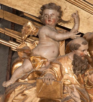 Zdjęcie nr 20: Nastawa jednoosiowa, jednokondygnacyjna ze zwieńczeniem, na wysokim dwustrefowym cokole z wyodrębnionymi czterema prostopadłościanami. Ołtarz kamienny, prostopadłościenny, z kamienną mensą. Antepedium ujęte srebrzoną opaską z napisem „kości ich niech wypuszczą pędu ze swego miejsca, aby byli wsławieni przez swoich synów”, pole podzielone na cztery części ornamentem roślinnym, każda wypełniona złoconą wicią kwiatową i czterema okrągłymi prześwitami. Na ołtarzu ustawione tabernakulum w formie Arki Przymierza. Nastawa ujęta dwiema parami pilastrów i dwiema parami kolumn o kręconych trzonach ustawionych pod kątem na zewnątrz, dźwigającymi pełne belkowanie z kostkowaniem, wyłamane na ich osi, przerwane nad polem środkowym oraz fragmenty przerwanego, półkolistego przyczółka. W polu środkowym wnęka w formie stojącego prostokąta zamkniętego łukiem półkolistym, w niej mniejszy obraz w kształcie stojącego prostokąta zamkniętego łukiem półkolistym nadwieszonym z przedstawieniem Wizji św. Franciszka, ujęty ramą dekorowaną rocaille&#039;em. Zwieńczenie w formie grupy rzeźbiarskiej Przemienienia Pańskiego na tle obłoków i w glorii promienistej. 
W partii belkowania nad polem głównym, na rzeźbionej skale podtrzymywanej przez rocaille klęczące postacie św. Piotra, św. Jana i św. Jakuba w dynamicznych pozach. Nad nimi unosi się Chrystus w otoku z obłoków i glorii, flankowany przez figury Mojżesza i Eliasza klęczące na przerwanym przyczółku, za nimi nadlatujące putta na obłokach. Po lewej stronie Piotr klęczący frontalnie z uniesionymi rękami. Obok niego klęczący św. Jan zwrócony profilem w lewo, z rękami wyciągniętymi w przód, o młodzieńczych rysach i długich, kręconych włosach. Święty Jakub po prawej stronie, w pozycji siedzącej, zwrócony w trzech czwartych w prawo z rękami wyciągniętymi w lewo. Wszyscy ubrani w przylegające do ciała tuniki oraz płaszcze przepasane w partii nóg. Nad nimi Chrystus w pozycji stojącej, frontalnie, w kontrapoście, z uniesioną głową i rękami rozłożonymi na boki, ubrany jest w tunikę oraz płaszcz przewiązany przez lewe ramię i wokół nóg. Na lewym fragmencie przyczółka klęczy Eliasz, zwrócony w trzech czwartych w lewo, pochylony, prawą ręką przytrzymuje na boku księgę, lewą wyciąga w przód. Ubrany jest w tunikę oraz rozwiany płaszcz. Na prawym fragmencie przyczółka klęczy Mojżesz, zwrócony w trzech czwartych w prawo, z pochylona głową, obiema rękami trzyma tablice przykazań. Ubrany jest w tunikę o krótkich rękawach oraz płaszcz zawinięty na lewym ramieniu i opadający na nogi. Obaj prorocy ukazani jako starcy. Nastawa flankowana dwoma wspornikami z figurami św. Wacława i św. Floriana. Struktura polichromowana w kolorze beżowym z żółtymi detalami oraz złoconymi profilami, ornamentyką i zwieńczeniem. Figury w partii ciała polichromowane naturalistycznie z brązowymi włosami i brodami oraz złoconymi szatami i atrybutami. 

