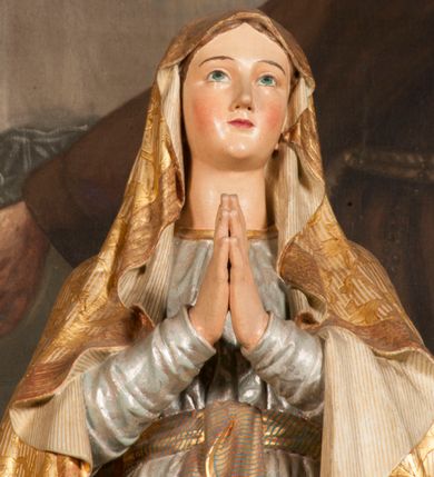 Zdjęcie nr 97: Tabernakulum w formie Arki Przymierza, adorowanej przez dwie klęczące figury starotestamentowego arcykapłana i biskupa oraz dwie stojące postacie lewitów oraz klęczące aniołów, zwieńczonej glorią promienistą z okiem Opatrzności. Wsparte na ośmiu cylindrycznych nóżkach prostopadłościenne tabernakulum jest od frontu podzielone na trzy pola wyznaczone kanelowanymi listwami. Pole środkowe stanowią drzwiczki z rytymi cyframi Dekalogu z ukrzyżowanym Chrystusem, pola boczne z wiązką pałek wodnych z jednej i winnym gronem z drugiej strony. Na skłębionych chmurach z podestem leży Baranek (obecnie w jego miejscu znajduje się figura Matki Boskiej). W tle znacznej wielkości gloria promienista z wieńcem chmur i umieszczonym w nim okiem Opatrzności oraz dwie uskrzydlone główki, nad którymi papieska tiara ze skrzyżowanymi kluczami. Po bokach Baranka dwa klęczące, uskrzydlone nagie aniołki. Obok tabernakulum dwie klęczące postacie z kadzielnicami w rękach. Postać po lewej w stroju biskupim, w albie, stule i kapie oraz infule z dwiema taśmami. Postać po prawej stronie jest ubrany w tradycyjny starotestamentowy strój – efod czyli tunikę i płaszcz wierzchni przepasany na biodrach, pektorał na piersi i zawój na głowie. Za nimi dwaj stojący lewici w tunikach przepasanych na biodrach i wysokich butach. Adorujące Baranka anioły w pozycji klęczącej z rękami skrzyżowanymi na piersi, ze skrzydłami na plecach i nogami w połowie utworzonymi ze skrzydeł.  


