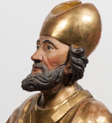 Zdjęcie nr 22: Tabernakulum w formie Arki Przymierza, adorowanej przez dwie klęczące figury starotestamentowego arcykapłana i biskupa oraz dwie stojące postacie lewitów oraz klęczące aniołów, zwieńczonej glorią promienistą z okiem Opatrzności. Wsparte na ośmiu cylindrycznych nóżkach prostopadłościenne tabernakulum jest od frontu podzielone na trzy pola wyznaczone kanelowanymi listwami. Pole środkowe stanowią drzwiczki z rytymi cyframi Dekalogu z ukrzyżowanym Chrystusem, pola boczne z wiązką pałek wodnych z jednej i winnym gronem z drugiej strony. Na skłębionych chmurach z podestem leży Baranek (obecnie w jego miejscu znajduje się figura Matki Boskiej). W tle znacznej wielkości gloria promienista z wieńcem chmur i umieszczonym w nim okiem Opatrzności oraz dwie uskrzydlone główki, nad którymi papieska tiara ze skrzyżowanymi kluczami. Po bokach Baranka dwa klęczące, uskrzydlone nagie aniołki. Obok tabernakulum dwie klęczące postacie z kadzielnicami w rękach. Postać po lewej w stroju biskupim, w albie, stule i kapie oraz infule z dwiema taśmami. Postać po prawej stronie jest ubrany w tradycyjny starotestamentowy strój – efod czyli tunikę i płaszcz wierzchni przepasany na biodrach, pektorał na piersi i zawój na głowie. Za nimi dwaj stojący lewici w tunikach przepasanych na biodrach i wysokich butach. Adorujące Baranka anioły w pozycji klęczącej z rękami skrzyżowanymi na piersi, ze skrzydłami na plecach i nogami w połowie utworzonymi ze skrzydeł.  


