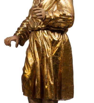 Zdjęcie nr 53: Tabernakulum w formie Arki Przymierza, adorowanej przez dwie klęczące figury starotestamentowego arcykapłana i biskupa oraz dwie stojące postacie lewitów oraz klęczące aniołów, zwieńczonej glorią promienistą z okiem Opatrzności. Wsparte na ośmiu cylindrycznych nóżkach prostopadłościenne tabernakulum jest od frontu podzielone na trzy pola wyznaczone kanelowanymi listwami. Pole środkowe stanowią drzwiczki z rytymi cyframi Dekalogu z ukrzyżowanym Chrystusem, pola boczne z wiązką pałek wodnych z jednej i winnym gronem z drugiej strony. Na skłębionych chmurach z podestem leży Baranek (obecnie w jego miejscu znajduje się figura Matki Boskiej). W tle znacznej wielkości gloria promienista z wieńcem chmur i umieszczonym w nim okiem Opatrzności oraz dwie uskrzydlone główki, nad którymi papieska tiara ze skrzyżowanymi kluczami. Po bokach Baranka dwa klęczące, uskrzydlone nagie aniołki. Obok tabernakulum dwie klęczące postacie z kadzielnicami w rękach. Postać po lewej w stroju biskupim, w albie, stule i kapie oraz infule z dwiema taśmami. Postać po prawej stronie jest ubrany w tradycyjny starotestamentowy strój – efod czyli tunikę i płaszcz wierzchni przepasany na biodrach, pektorał na piersi i zawój na głowie. Za nimi dwaj stojący lewici w tunikach przepasanych na biodrach i wysokich butach. Adorujące Baranka anioły w pozycji klęczącej z rękami skrzyżowanymi na piersi, ze skrzydłami na plecach i nogami w połowie utworzonymi ze skrzydeł.  


