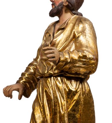 Zdjęcie nr 50: Tabernakulum w formie Arki Przymierza, adorowanej przez dwie klęczące figury starotestamentowego arcykapłana i biskupa oraz dwie stojące postacie lewitów oraz klęczące aniołów, zwieńczonej glorią promienistą z okiem Opatrzności. Wsparte na ośmiu cylindrycznych nóżkach prostopadłościenne tabernakulum jest od frontu podzielone na trzy pola wyznaczone kanelowanymi listwami. Pole środkowe stanowią drzwiczki z rytymi cyframi Dekalogu z ukrzyżowanym Chrystusem, pola boczne z wiązką pałek wodnych z jednej i winnym gronem z drugiej strony. Na skłębionych chmurach z podestem leży Baranek (obecnie w jego miejscu znajduje się figura Matki Boskiej). W tle znacznej wielkości gloria promienista z wieńcem chmur i umieszczonym w nim okiem Opatrzności oraz dwie uskrzydlone główki, nad którymi papieska tiara ze skrzyżowanymi kluczami. Po bokach Baranka dwa klęczące, uskrzydlone nagie aniołki. Obok tabernakulum dwie klęczące postacie z kadzielnicami w rękach. Postać po lewej w stroju biskupim, w albie, stule i kapie oraz infule z dwiema taśmami. Postać po prawej stronie jest ubrany w tradycyjny starotestamentowy strój – efod czyli tunikę i płaszcz wierzchni przepasany na biodrach, pektorał na piersi i zawój na głowie. Za nimi dwaj stojący lewici w tunikach przepasanych na biodrach i wysokich butach. Adorujące Baranka anioły w pozycji klęczącej z rękami skrzyżowanymi na piersi, ze skrzydłami na plecach i nogami w połowie utworzonymi ze skrzydeł.  


