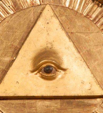 Zdjęcie nr 70: Tabernakulum w formie Arki Przymierza, adorowanej przez dwie klęczące figury starotestamentowego arcykapłana i biskupa oraz dwie stojące postacie lewitów oraz klęczące aniołów, zwieńczonej glorią promienistą z okiem Opatrzności. Wsparte na ośmiu cylindrycznych nóżkach prostopadłościenne tabernakulum jest od frontu podzielone na trzy pola wyznaczone kanelowanymi listwami. Pole środkowe stanowią drzwiczki z rytymi cyframi Dekalogu z ukrzyżowanym Chrystusem, pola boczne z wiązką pałek wodnych z jednej i winnym gronem z drugiej strony. Na skłębionych chmurach z podestem leży Baranek (obecnie w jego miejscu znajduje się figura Matki Boskiej). W tle znacznej wielkości gloria promienista z wieńcem chmur i umieszczonym w nim okiem Opatrzności oraz dwie uskrzydlone główki, nad którymi papieska tiara ze skrzyżowanymi kluczami. Po bokach Baranka dwa klęczące, uskrzydlone nagie aniołki. Obok tabernakulum dwie klęczące postacie z kadzielnicami w rękach. Postać po lewej w stroju biskupim, w albie, stule i kapie oraz infule z dwiema taśmami. Postać po prawej stronie jest ubrany w tradycyjny starotestamentowy strój – efod czyli tunikę i płaszcz wierzchni przepasany na biodrach, pektorał na piersi i zawój na głowie. Za nimi dwaj stojący lewici w tunikach przepasanych na biodrach i wysokich butach. Adorujące Baranka anioły w pozycji klęczącej z rękami skrzyżowanymi na piersi, ze skrzydłami na plecach i nogami w połowie utworzonymi ze skrzydeł.  


