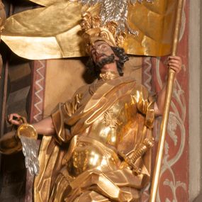 Zdjęcie nr 1: Rzeźba zwrócona w trzech czwartych w prawo, z uniesioną głową, o esowato wygiętej sylwetce, lewą nogę opiera na fragmencie płaszcza. Święty Florian w lewej uniesionej ręce trzyma drzewce rozwianej chorągwi z wizerunkiem orła w koronie, prawą wylewa z dzbana wodę na płonący budynek kościoła stojący przy jego prawej nodze. Twarz ma szczupłą, o dużych, głęboko rzeźbionych oczach, skierowanych w górę i uniesionych, zmarszczonych brwiach, dużym, lekko garbatym i zadartym nosie oraz rozchylonych ustach, okoloną krótką, silnie kręconą brodą oraz rozwianymi na boki włosami. Ubrany jest w krótką tunikę oraz zbroję torsową, przez biodra ma przewiązany pas z zawieszonym przy lewym boku mieczem. Przez lewe ramię ma zawiązany diagonalnie płaszcz, opadający na prawe przedramię oraz zawinięty na lewe udo. Na głowie ma hełm dekorowany maszkaronem z pióropuszem, a na nogach wysokie buty. Polichromia ciała naturalistyczna, włosy brązowe, strój i atrybuty złocone, detale srebrzone. 

