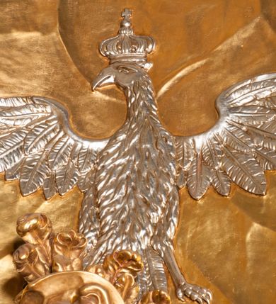 Zdjęcie nr 11: Rzeźba zwrócona w trzech czwartych w prawo, z uniesioną głową, o esowato wygiętej sylwetce, lewą nogę opiera na fragmencie płaszcza. Święty Florian w lewej uniesionej ręce trzyma drzewce rozwianej chorągwi z wizerunkiem orła w koronie, prawą wylewa z dzbana wodę na płonący budynek kościoła stojący przy jego prawej nodze. Twarz ma szczupłą, o dużych, głęboko rzeźbionych oczach, skierowanych w górę i uniesionych, zmarszczonych brwiach, dużym, lekko garbatym i zadartym nosie oraz rozchylonych ustach, okoloną krótką, silnie kręconą brodą oraz rozwianymi na boki włosami. Ubrany jest w krótką tunikę oraz zbroję torsową, przez biodra ma przewiązany pas z zawieszonym przy lewym boku mieczem. Przez lewe ramię ma zawiązany diagonalnie płaszcz, opadający na prawe przedramię oraz zawinięty na lewe udo. Na głowie ma hełm dekorowany maszkaronem z pióropuszem, a na nogach wysokie buty. Polichromia ciała naturalistyczna, włosy brązowe, strój i atrybuty złocone, detale srebrzone. 

