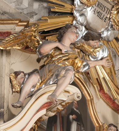 Zdjęcie nr 7: Nastawa architektoniczna, jednoosiowa, jednokondygnacyjna, ze zwieńczeniem, ustawiona na dwustrefowym cokole z wyodrębnionymi prostopadłościanami i konsolami. Ołtarz kamienny, prostopadłościenny, z kamienną mensą z portatylem. Antepedium kamienne, ujęte opaską, z rzeźbionymi maswerkami w polu. Nastawa flankowana parą opilastrowanych filarów, o kanelowanych trzonach i kapitelach kompozytowych, ustawionych pod kątem na zewnątrz, dekorowanych kwiatowymi zwisami, dźwigających pełne belkowanie wyłamane na ich osi oraz fragmenty falistego, przerwanego przyczółka z figurami aniołów. Na tle filarów ustawione figury św. Piotra i św. Pawła. Niemal całe pole główne wypełnione wnęką w formie stojącego prostokąta zamkniętego łukiem półkolistym nadwieszonym ujętą profilowaną ramą dekorowaną rocaille&#039;m, z mniejszym obrazem Rodziny Marii ze św. Janem Chrzcicielem, w osobnej, profilowanej ramie. Nad nim, w partii belkowania rocaille&#039;owy kartusz z napisem „REGNI / ET PROTECTORIBUS”. Zwieńczenie w formie leżącego prostokąta zamkniętego fragmentem falistego gzymsu. W polu obraz św. Jacka i bł. Czesława w kształcie trapezu o wklęsłych bokach, zamkniętego łukiem segmentowym nadwieszonym, ujęty ramą; flankowany dwiema parami uskrzydlonych główek anielskich. Zwieńczenie zamknięte medalionem z napisem „CHRISTI / FAMILIAE” w otoku z obłoków i uskrzydlonych główek anielskich, w glorii promienistej. Nastawa polichromowana w kolorze beżowym z detalami malowanymi na sposób imitujący jasnoróżowy marmur, ornamentyka i profile złocone. 
