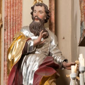 Zdjęcie nr 1: Figura drążona z tyłu, ustawiona na nieregularnej podstawie. Święty zwrócony frontalnie, z głową skierowaną w prawo, w kontrapoście, o esowato wygiętej sylwetce. W lewej, wyciągniętej w bok ręce trzyma miecz skierowany ostrzem w dół, prawą, ugiętą, unosi na tle piersi. Twarz ma pociągłą, o migdałowatych, blisko siebie osadzonych oczach, lekko garbatym nosie oraz pełnych, rozchylonych ustach. Okolona jest długą, falowaną brodą, opadającą na pierś oraz krótkimi, kręconymi, brązowymi włosami. Ubrany jest w srebrzoną tunikę, przepasaną w talii oraz złocony płaszcz z czerwoną podszewką, zarzucony na prawe ramię i opadający na lewa nogę. Polichromia ciała naturalistyczna.

