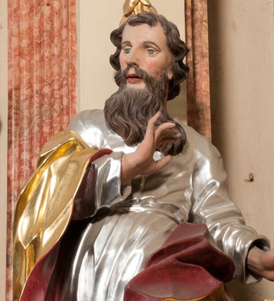 Zdjęcie nr 4: Figura drążona z tyłu, ustawiona na nieregularnej podstawie. Święty zwrócony frontalnie, z głową skierowaną w prawo, w kontrapoście, o esowato wygiętej sylwetce. W lewej, wyciągniętej w bok ręce trzyma miecz skierowany ostrzem w dół, prawą, ugiętą, unosi na tle piersi. Twarz ma pociągłą, o migdałowatych, blisko siebie osadzonych oczach, lekko garbatym nosie oraz pełnych, rozchylonych ustach. Okolona jest długą, falowaną brodą, opadającą na pierś oraz krótkimi, kręconymi, brązowymi włosami. Ubrany jest w srebrzoną tunikę, przepasaną w talii oraz złocony płaszcz z czerwoną podszewką, zarzucony na prawe ramię i opadający na lewa nogę. Polichromia ciała naturalistyczna.

