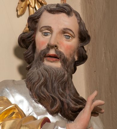 Zdjęcie nr 9: Figura drążona z tyłu, ustawiona na nieregularnej podstawie. Święty zwrócony frontalnie, z głową skierowaną w prawo, w kontrapoście, o esowato wygiętej sylwetce. W lewej, wyciągniętej w bok ręce trzyma miecz skierowany ostrzem w dół, prawą, ugiętą, unosi na tle piersi. Twarz ma pociągłą, o migdałowatych, blisko siebie osadzonych oczach, lekko garbatym nosie oraz pełnych, rozchylonych ustach. Okolona jest długą, falowaną brodą, opadającą na pierś oraz krótkimi, kręconymi, brązowymi włosami. Ubrany jest w srebrzoną tunikę, przepasaną w talii oraz złocony płaszcz z czerwoną podszewką, zarzucony na prawe ramię i opadający na lewa nogę. Polichromia ciała naturalistyczna.

