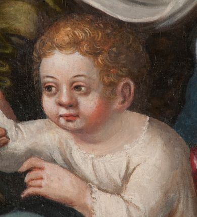 Zdjęcie nr 5: Obraz w formie stojącego prostokąta zamkniętego łukiem półkolistym nadwieszonym z przedstawieniem Rodziny Marii i św. Janem Chrzcicielem. Po prawej stronie obrazu siedzące obok siebie św. Anna i Maria z Dzieciątkiem, zwrócone w trzech czwartych w prawo. Maria z pochyloną głową, dłonie ma złożone w geście modlitwy, lewą nogę wysuniętą do przodu. Twarz ma owalną, o łagodnych, młodzieńczych rysach, okoloną brązowymi włosami, ukrytymi pod welonem. Ubrana jest w ciemnoróżową suknię oraz niebieski płaszcz z żółtą podszewką zarzucony na prawe ramię i opadający na kolana, na głowie i wokół szyi ma biały welon. Na jej kolanie siedzi Dzieciątko Jezus, lekko pochylone z uniesionymi obiema rękami, prawą rękę ma podtrzymywaną przez św. Annę, a dłoń w geście błogosławieństwa. Twarz ma pełną, o pucołowatych policzkach, okoloną krótkimi, kręconymi, jasnymi włosami. Ubrane jest w białą tunikę lamowaną koronką. Anna lekko pochylona w przód, lewą ręką obejmuje Marię, prawą podtrzymuje dłoń Dzieciątka. Twarz ma o starczych, łagodnych rysach. Ubrana jest w zieloną suknię oraz biały welon z podwiką. Obie razem z Marią mają na głowach aplikowane korony zamknięte. W lewej części obrazu klęczący przed nimi św. Joachim i św. Jan Chrzciciel. Ten ostatni ukazany jako dziecko, klęczy na prawym kolanie, lekko pochylony, w lewej ręce trzyma laskę zakończoną krzyżem z banderolą z napisem „ECCE AGNVS DEI”, prawą kładzie na piersi. Twarz ma pełną o pucołowatych policzkach, okoloną jasnymi, kręconymi, krótkimi włosami. Ubrany jest w pomarańczowo-różową melotę. Święty Joachim klęczy pochylony za nim, prawą rękę opiera na postumencie, lewą kładzie na piersi. Twarz ma o starczych rysach, okoloną siwą brodą i włosami, nad głową aplikowana gloria promienista. Ubrany jest w zieloną tunikę oraz pomarańczowy płaszcz zarzucony na ramiona. Postacie znajdują się we wnętrzu z szachownicową posadzką oraz upiętymi po bokach czerwonymi draperiami. W górnej części obrazu, pośród obłoków ukazane półpostacie czterech aniołów, ubranych w kolorowe tuniki, z których dwa trzymają otwarte księgi. Tło złocone. 

