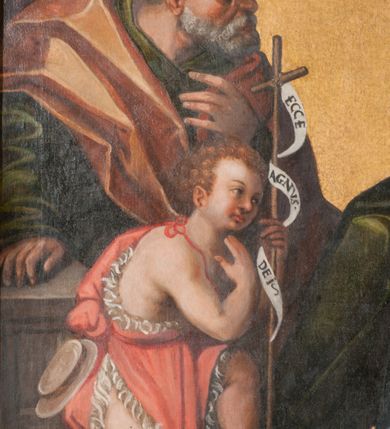 Zdjęcie nr 16: Obraz w formie stojącego prostokąta zamkniętego łukiem półkolistym nadwieszonym z przedstawieniem Rodziny Marii i św. Janem Chrzcicielem. Po prawej stronie obrazu siedzące obok siebie św. Anna i Maria z Dzieciątkiem, zwrócone w trzech czwartych w prawo. Maria z pochyloną głową, dłonie ma złożone w geście modlitwy, lewą nogę wysuniętą do przodu. Twarz ma owalną, o łagodnych, młodzieńczych rysach, okoloną brązowymi włosami, ukrytymi pod welonem. Ubrana jest w ciemnoróżową suknię oraz niebieski płaszcz z żółtą podszewką zarzucony na prawe ramię i opadający na kolana, na głowie i wokół szyi ma biały welon. Na jej kolanie siedzi Dzieciątko Jezus, lekko pochylone z uniesionymi obiema rękami, prawą rękę ma podtrzymywaną przez św. Annę, a dłoń w geście błogosławieństwa. Twarz ma pełną, o pucołowatych policzkach, okoloną krótkimi, kręconymi, jasnymi włosami. Ubrane jest w białą tunikę lamowaną koronką. Anna lekko pochylona w przód, lewą ręką obejmuje Marię, prawą podtrzymuje dłoń Dzieciątka. Twarz ma o starczych, łagodnych rysach. Ubrana jest w zieloną suknię oraz biały welon z podwiką. Obie razem z Marią mają na głowach aplikowane korony zamknięte. W lewej części obrazu klęczący przed nimi św. Joachim i św. Jan Chrzciciel. Ten ostatni ukazany jako dziecko, klęczy na prawym kolanie, lekko pochylony, w lewej ręce trzyma laskę zakończoną krzyżem z banderolą z napisem „ECCE AGNVS DEI”, prawą kładzie na piersi. Twarz ma pełną o pucołowatych policzkach, okoloną jasnymi, kręconymi, krótkimi włosami. Ubrany jest w pomarańczowo-różową melotę. Święty Joachim klęczy pochylony za nim, prawą rękę opiera na postumencie, lewą kładzie na piersi. Twarz ma o starczych rysach, okoloną siwą brodą i włosami, nad głową aplikowana gloria promienista. Ubrany jest w zieloną tunikę oraz pomarańczowy płaszcz zarzucony na ramiona. Postacie znajdują się we wnętrzu z szachownicową posadzką oraz upiętymi po bokach czerwonymi draperiami. W górnej części obrazu, pośród obłoków ukazane półpostacie czterech aniołów, ubranych w kolorowe tuniki, z których dwa trzymają otwarte księgi. Tło złocone. 

