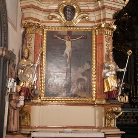 Zdjęcie nr 1: Nastawa architektoniczna, jednoosiowa, jednokondygnacyjna, ze zwieńczeniem, ustawiona na dwustrefowym cokole z wyodrębnionymi prostopadłościanami i konsolami. Ołtarz kamienny, prostopadłościenny, z kamienną mensą. Antepedium kamienne, ujęte opaską, podzielone dwoma kolumienkami na cokołach na trzy pola, każde wypełnione płaskorzeźbionymi kwiatami i prześwitami. Nastawa flankowana parą opilastrowanych filarów, o kanelowanych trzonach o kapitelach kompozytowych, ustawionych pod kątem na zewnątrz, dekorowanych kwiatowymi zwisami, dźwigających pełne belkowanie wyłamane na ich osi oraz fragmenty falistego, przerwanego przyczółka z figurami aniołów. Na tle filarów ustawione figury św. Stanisława i św. Wojciecha. Całe pole główne wypełnione wnęką w formie stojącego prostokąta ujętego ramą dekorowaną ornamentem geometrycznym, z obrazem Ukrzyżowania. Nad nim, w partii belkowania wolutowy kartusz z napisem „PA=/TRO=/NO”. Zwieńczenie w formie leżącego prostokąta zamkniętego fragmentem falistego gzymsu. W polu obraz św. Kingi w kształcie trapezu o wklęsłych bokach, zamkniętego łukiem segmentowym nadwieszonym, ujęty ramą; flankowany dwiema uskrzydlonymi główkami anielskimi. Zwieńczenie zamknięte wolutowym kartuszem przeplatanym tkaniną z napisem „RE=GNI”. Nastawa polichromowana w kolorze beżowym z detalami malowanymi na sposób imitujący jasnoróżowy marmur, ornamentyka i profile złocone. 
