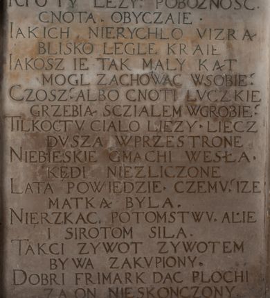 Zdjęcie nr 8: Nagrobek Grzegorza i Katarzyny Branickich znajduje się w kaplicy rodowej pod wezwaniem Najświętszej Marii Panny, na ścianie południowej, naprzeciwko wejścia. Składa się z trójosiowego cokołu i potrójnej filarowo-kolumnowej arkady z klęczącymi postaciami zmarłych po bokach adorujących znajdującą się pośrodku scenę ze zmartwychwstałym Chrystusem ukazującym się niewiernemu Tomaszowi. Całość wieńczy półkolista arkada z herbami Gryf i Kotwicz i tablicami inskrypcyjnymi. 
Dolna część artykułowa lizenami ozdobionymi motywami kandelabrowymi. W polu środkowym czaszka ze skrzyżowanymi piszczelami z inskrypcją w górnej i dolnej części: „POWIEDZ SVIETA [M]ADROSCI IESLI ZE SMIERC ZIWA / CZI MARTWA IESLI MARTWA CZEMV ZIWĄ BIWA / MALOWANA A IESLI ZIWA SMIERCIĄ CZEMV / ZOWIĄ IĄ NAD TO ZYWOT PRZECZ BIERZE KOZI/DEMV / TA IEST NA TWE PITANIE ODPOWIEC PRAWDZIWA / GDI TI ZYESZ SMIERC MARTVA GDY VMIERAS ZIWA / A IESLI ZLA CZI DOBRA CHCZES WIEDZIEC LI O TYM / IAKIS SĄM TAKĄ SMIELE SMIERC MIEĆ BĘDZIESZ PO TYM”. Na lewym polu inskrypcja „CO ZA DZIW ZEM POPIOLEM / WIEDZCIE ZESCIE WY / IAKO IA TENZE POPIOL, TO / IEDNO ZE ZYWY / BO GDIM SIĘ W PROCH ROSSIPAL / DOPIROM PRAWDZIWIE DOSZEDL, ZE CZLOWIEK TYMZE / PROCHEM CHOCIA ZYWIE / PATRZ ZE ZYWY POPIELIE A / TO POMNI SOBIE / ZES NA SWIECIE POPIOLEM / POPIOLEM I W GROBIE / A ZASZ NIEWIES CZYMEM BYL / A TERAZEM IAKI / OGLIANDAI, VWAZAIACZ ZE / SAM BEDZIESZ TAKI / BYLEM TERAS MIE NIE MASZ / IAK BIM TISZ NA SWIECIE / NIE BYL WY DZIS IESTESCIE / IUTRO NIEBEDZIECIE”. W polu cokołu „KTO TV LEZY POBOZNOSC / CNOTA OBYCZAIE / IAKICH NIERYCHLO VIZRĄ / BLISKO LEGLE KRAIE / IAKOSZ IE TAK MALY KĄT / MOGL ZACHOWAC W SOBIE / CZOSZ ALBO CNOTI LVCZKIE / GRZEBIĄ SCZIALEM W GROBIE / TILKOC TV CIALO LIEZY LIECZ / DVSZA W PRZESTRONE / NIEBIESKIE GMACHI WESŁA / KĘDI NIEZLICZONE / LATA POWIEDZIE. CZEMV IZE / MATKĄ BYLA / NIERZKAC POTOMSTWV ALIE / I SIROTOM SILA / TAKCI ZYWOT ZYWOTEM BYWA ZAKVPIONY / DOBRI FRIMARK DAC PLOCHI / ZA ON NIESKONCZONY”. Cokół zamyka wąski, silnie wysunięty gzyms z kimationem jońskim.
Trójosiowy podział nagrobka jest zachowany w partii środkowej, składającej się z trzech arkadowych wnęk, z których środkowa ujęta jest wolnostojącymi kolumnami jońskimi pokrytymi spiralnie ułożonymi pasami z motywem wici roślinnej, a sąsiednie od zewnątrz flankowane filarami pokrytymi motywami kandelabrowymi. W niezbyt głębokich niszach, których podniebienia zdobią kasetony z rozetami w kluczach uskrzydlone główki aniołków umieszczono wykonane w marmurze pińczowskim płaskorzeźby Chrystusa Zmartwychwstałego i adorujących go zmarłych, Grzegorza i Katarzynę Branickich. 
Zbawiciel jest ujęty całopostaciowo, frontalnie, w niewielkim wykroku, z głową zwróconą lekko do klęczącego po prawej stronie św. Tomasza. Jego ciało jest smukłe, wąskie w ramionach, z zaznaczonymi żebrami i mięśniami, osłonięte przewiązaną na biodrach szatą i płaszczem na lewym ramieniu. Chrystus ma pociągłą twarz, o wysokim czole, szerokich kościach policzkowych, wydatnym nosie i z głębokimi oczodołami. Przedstawiony został z długimi wąsami i brodą oraz opadającymi na ramiona, kręconymi włosami. W lewej ręce trzyma chorągiew i podtrzymuje szatę, a prawą rękę ma opuszczoną ku dołowi. 
Święty Tomasz ukazany jest z profilu, w szacie podwójnie przewiązanej w pasie sznurem i przerzuconym przez lewe ramie płaszczem. Twarz z brodą i długimi włosami, odwrócona w stronę Chrystusa. Do góry unosi również prawą rękę, zachowaną tylko do łokcia, lewą rękę trzyma ponad pasem. Figura mężczyzny wyrzeźbiona w kamieniu, polichromowana, przysłania wieniec z obłoków i uskrzydlonych głów puttów otaczający Chrystusa. 
Postacie stoją na podwójnym postumencie. W jego górnej części wyryto sentencję łacińską na prostokątnej tablicy umieszczonej w ozdobnym kartuszu, z zawiniętym spiralnie wycięciem krawędzi górnej i z dodaną w krawędzi dolnej główką uskrzydlonego putta. Napis na postumencie: „PER QVEM ET NOS / RESVRGERE DEVOTA / MENTE, CREDIMVS”. Na płycie poniżej płaskorzeźbione, leżące na prawym boku putto podpierające głowę na prawej ręce, natomiast w lewej trzymające klepsydrę. Nagie ciało, lekko przysłonięte draperią, spoczywa na poduszce z dwoma pomponami. Prawa noga jest wyprostowana, lewa zgięta w kolanie. Twarz pucołowata, z otwartymi oczami, otoczona gęstymi puklami loków. Przed dzieckiem leży czaszka. Nad nim znajduje się grawerowany kartusz z napisem: „HODIE MIHI / CRAS TIBI”. 
W arkadzie po lewej stronie przedstawiony został w trzech czwartych, zwrócony ramionami do widza Grzegorz Branicki. Postać klęczy na poduszce, szerokie dłonie złożone ma razem na piersiach, a głowę lekko uniesioną. Twarz Branickiego o pociągłych rysach, szerokich kościach policzkowych i dużych oczach, z wysokim czołem przysłoniętym zaczesanymi do przodu włosami. Ukazany z wąsami i długą, pofalowaną brodą. Ubrany jest w pełną, dekorowaną zbroję, spod której wystaje jaka i nogawice. Na szyi zawieszony łańcuch, a u stóp ostrogi. Przy nogach Branickiego leżą rękawice i hełm z trzema piórami. Nad głową wznoszą się panoplia, złożone z okrągłej tarczy i skrzyżowanych miecza, szabli, buławy, łuku, kołczanu ze strzałami i włóczni.
Po lewej stronie arkadę wypełnia ujęta z profilu, postać klęczącej na dwóch kolanach Katarzyny Branickiej. Jest ubrana w długą szubę, opadającą sztywnymi, rozchodzącymi się fałdami, u dołu załamującymi się, które zasłaniają sylwetkę. Na głowie ma czepiec przysłaniający włosy i podwikę. Twarz o łagodnych rysach, z długim nosem, małymi ustami i lekko zadartym podbródkiem. Ręce złożone razem na piersiach. Na palcach wskazującym i serdecznym lewej dłoni pierścienie, a ponad nadgarstkiem czterokrotnie nawinięty różaniec. Ponad figurą płaskorzeźbione tondo z Matką Boską z Dzieciątkiem otoczonymi wieńcem obłoków. Maria siedzi, ubrana w długą suknię, z welonem na głowie, z płaszczem zarzuconym na ramiona, którym lekko okrywa nagie Dzieciątko.
Zwieńczenie nagrobka o brzegach inkrustowanych marmurowymi kołami i elipsami, ujęte ornamentalnymi uszami, jest zakończone pasem z zawijającymi się do środkami kartuszami i równolegle ułożonymi liśćmi akantu. Tympanon wypełnia dekoracja złożona z czterech kartuszy: dwóch owalnych na tle paludamentu, zwieńczonych uskrzydloną główką anioła z godłami herbów Gryf i Kotwicz i dwóch podłużnych z inskrypcjami. Na tablicy po lewej stronie inskrypcja: „MAGNIFICO D(OMI)NO GREGORIO A RUSCA BRANICZKI OLIM VENA/TORI ET BURGRABIO CRAC(OVIENSI) CAPITANEO NIEPOŁOMIECEN(SI) VIRO / INTEGERRIMO DE REGIBVS SVIS ET RE PVB(LICA) BENE MERITO RELIGIO/NIS CATHOLICE AMANTISSIMO AMICIS FIDELISSIMO, OMNIBVS AFFABI/LI ET BENIGNO JOANNES A RUSCA BRANICZKI VENATOR CRACO(VIENSIS) CAPITANEVS NIEPOŁOMICEN(SI) MESTVS FILIUS PARENTI CHA/RISSIMO POSVIT OBYT 9 MAII A(NNO) D(OMINI) 1595 AETATIS SUE 60”. Napis wykuty po prawej stronie: “MAGNIFICAE D(OMI)NE CATHARINAE MAGNIFICI OLIM D(OMI)NI AUGUSTINI / KOTFICZ D(OMINI) SIGISMVNDI I POLONIAE REGIS STABVLI PREFECTI / VEXILIFERISQUE CURIE ET BURGRABY CRACO(VIENSIS) FILIE MATRONAE / LECTISSIME QVE CVM PVDORE ET MORVM MIRA ELEGANTIA / MARITI SUMMUM AMOREM VIRTUTE ET MODESTIA OMNIVM BENE/VOLENTIAM MERVISSET ACERBISSIMA MORTE AB OCVLIS EREPTA EST / IDEM FILIUS MATRI AMANTISSIME CVM LACRIMIS POSVIT. OBYT / 8 OCTOBRIS A(NNO) D)OMINI) 1588 AETATIS SUE 38&quot;. 
