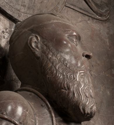 Zdjęcie nr 56: Nagrobek Grzegorza i Katarzyny Branickich znajduje się w kaplicy rodowej pod wezwaniem Najświętszej Marii Panny, na ścianie południowej, naprzeciwko wejścia. Składa się z trójosiowego cokołu i potrójnej filarowo-kolumnowej arkady z klęczącymi postaciami zmarłych po bokach adorujących znajdującą się pośrodku scenę ze zmartwychwstałym Chrystusem ukazującym się niewiernemu Tomaszowi. Całość wieńczy półkolista arkada z herbami Gryf i Kotwicz i tablicami inskrypcyjnymi. 
Dolna część artykułowa lizenami ozdobionymi motywami kandelabrowymi. W polu środkowym czaszka ze skrzyżowanymi piszczelami z inskrypcją w górnej i dolnej części: „POWIEDZ SVIETA [M]ADROSCI IESLI ZE SMIERC ZIWA / CZI MARTWA IESLI MARTWA CZEMV ZIWĄ BIWA / MALOWANA A IESLI ZIWA SMIERCIĄ CZEMV / ZOWIĄ IĄ NAD TO ZYWOT PRZECZ BIERZE KOZI/DEMV / TA IEST NA TWE PITANIE ODPOWIEC PRAWDZIWA / GDI TI ZYESZ SMIERC MARTVA GDY VMIERAS ZIWA / A IESLI ZLA CZI DOBRA CHCZES WIEDZIEC LI O TYM / IAKIS SĄM TAKĄ SMIELE SMIERC MIEĆ BĘDZIESZ PO TYM”. Na lewym polu inskrypcja „CO ZA DZIW ZEM POPIOLEM / WIEDZCIE ZESCIE WY / IAKO IA TENZE POPIOL, TO / IEDNO ZE ZYWY / BO GDIM SIĘ W PROCH ROSSIPAL / DOPIROM PRAWDZIWIE DOSZEDL, ZE CZLOWIEK TYMZE / PROCHEM CHOCIA ZYWIE / PATRZ ZE ZYWY POPIELIE A / TO POMNI SOBIE / ZES NA SWIECIE POPIOLEM / POPIOLEM I W GROBIE / A ZASZ NIEWIES CZYMEM BYL / A TERAZEM IAKI / OGLIANDAI, VWAZAIACZ ZE / SAM BEDZIESZ TAKI / BYLEM TERAS MIE NIE MASZ / IAK BIM TISZ NA SWIECIE / NIE BYL WY DZIS IESTESCIE / IUTRO NIEBEDZIECIE”. W polu cokołu „KTO TV LEZY POBOZNOSC / CNOTA OBYCZAIE / IAKICH NIERYCHLO VIZRĄ / BLISKO LEGLE KRAIE / IAKOSZ IE TAK MALY KĄT / MOGL ZACHOWAC W SOBIE / CZOSZ ALBO CNOTI LVCZKIE / GRZEBIĄ SCZIALEM W GROBIE / TILKOC TV CIALO LIEZY LIECZ / DVSZA W PRZESTRONE / NIEBIESKIE GMACHI WESŁA / KĘDI NIEZLICZONE / LATA POWIEDZIE. CZEMV IZE / MATKĄ BYLA / NIERZKAC POTOMSTWV ALIE / I SIROTOM SILA / TAKCI ZYWOT ZYWOTEM BYWA ZAKVPIONY / DOBRI FRIMARK DAC PLOCHI / ZA ON NIESKONCZONY”. Cokół zamyka wąski, silnie wysunięty gzyms z kimationem jońskim.
Trójosiowy podział nagrobka jest zachowany w partii środkowej, składającej się z trzech arkadowych wnęk, z których środkowa ujęta jest wolnostojącymi kolumnami jońskimi pokrytymi spiralnie ułożonymi pasami z motywem wici roślinnej, a sąsiednie od zewnątrz flankowane filarami pokrytymi motywami kandelabrowymi. W niezbyt głębokich niszach, których podniebienia zdobią kasetony z rozetami w kluczach uskrzydlone główki aniołków umieszczono wykonane w marmurze pińczowskim płaskorzeźby Chrystusa Zmartwychwstałego i adorujących go zmarłych, Grzegorza i Katarzynę Branickich. 
Zbawiciel jest ujęty całopostaciowo, frontalnie, w niewielkim wykroku, z głową zwróconą lekko do klęczącego po prawej stronie św. Tomasza. Jego ciało jest smukłe, wąskie w ramionach, z zaznaczonymi żebrami i mięśniami, osłonięte przewiązaną na biodrach szatą i płaszczem na lewym ramieniu. Chrystus ma pociągłą twarz, o wysokim czole, szerokich kościach policzkowych, wydatnym nosie i z głębokimi oczodołami. Przedstawiony został z długimi wąsami i brodą oraz opadającymi na ramiona, kręconymi włosami. W lewej ręce trzyma chorągiew i podtrzymuje szatę, a prawą rękę ma opuszczoną ku dołowi. 
Święty Tomasz ukazany jest z profilu, w szacie podwójnie przewiązanej w pasie sznurem i przerzuconym przez lewe ramie płaszczem. Twarz z brodą i długimi włosami, odwrócona w stronę Chrystusa. Do góry unosi również prawą rękę, zachowaną tylko do łokcia, lewą rękę trzyma ponad pasem. Figura mężczyzny wyrzeźbiona w kamieniu, polichromowana, przysłania wieniec z obłoków i uskrzydlonych głów puttów otaczający Chrystusa. 
Postacie stoją na podwójnym postumencie. W jego górnej części wyryto sentencję łacińską na prostokątnej tablicy umieszczonej w ozdobnym kartuszu, z zawiniętym spiralnie wycięciem krawędzi górnej i z dodaną w krawędzi dolnej główką uskrzydlonego putta. Napis na postumencie: „PER QVEM ET NOS / RESVRGERE DEVOTA / MENTE, CREDIMVS”. Na płycie poniżej płaskorzeźbione, leżące na prawym boku putto podpierające głowę na prawej ręce, natomiast w lewej trzymające klepsydrę. Nagie ciało, lekko przysłonięte draperią, spoczywa na poduszce z dwoma pomponami. Prawa noga jest wyprostowana, lewa zgięta w kolanie. Twarz pucołowata, z otwartymi oczami, otoczona gęstymi puklami loków. Przed dzieckiem leży czaszka. Nad nim znajduje się grawerowany kartusz z napisem: „HODIE MIHI / CRAS TIBI”. 
W arkadzie po lewej stronie przedstawiony został w trzech czwartych, zwrócony ramionami do widza Grzegorz Branicki. Postać klęczy na poduszce, szerokie dłonie złożone ma razem na piersiach, a głowę lekko uniesioną. Twarz Branickiego o pociągłych rysach, szerokich kościach policzkowych i dużych oczach, z wysokim czołem przysłoniętym zaczesanymi do przodu włosami. Ukazany z wąsami i długą, pofalowaną brodą. Ubrany jest w pełną, dekorowaną zbroję, spod której wystaje jaka i nogawice. Na szyi zawieszony łańcuch, a u stóp ostrogi. Przy nogach Branickiego leżą rękawice i hełm z trzema piórami. Nad głową wznoszą się panoplia, złożone z okrągłej tarczy i skrzyżowanych miecza, szabli, buławy, łuku, kołczanu ze strzałami i włóczni.
Po lewej stronie arkadę wypełnia ujęta z profilu, postać klęczącej na dwóch kolanach Katarzyny Branickiej. Jest ubrana w długą szubę, opadającą sztywnymi, rozchodzącymi się fałdami, u dołu załamującymi się, które zasłaniają sylwetkę. Na głowie ma czepiec przysłaniający włosy i podwikę. Twarz o łagodnych rysach, z długim nosem, małymi ustami i lekko zadartym podbródkiem. Ręce złożone razem na piersiach. Na palcach wskazującym i serdecznym lewej dłoni pierścienie, a ponad nadgarstkiem czterokrotnie nawinięty różaniec. Ponad figurą płaskorzeźbione tondo z Matką Boską z Dzieciątkiem otoczonymi wieńcem obłoków. Maria siedzi, ubrana w długą suknię, z welonem na głowie, z płaszczem zarzuconym na ramiona, którym lekko okrywa nagie Dzieciątko.
Zwieńczenie nagrobka o brzegach inkrustowanych marmurowymi kołami i elipsami, ujęte ornamentalnymi uszami, jest zakończone pasem z zawijającymi się do środkami kartuszami i równolegle ułożonymi liśćmi akantu. Tympanon wypełnia dekoracja złożona z czterech kartuszy: dwóch owalnych na tle paludamentu, zwieńczonych uskrzydloną główką anioła z godłami herbów Gryf i Kotwicz i dwóch podłużnych z inskrypcjami. Na tablicy po lewej stronie inskrypcja: „MAGNIFICO D(OMI)NO GREGORIO A RUSCA BRANICZKI OLIM VENA/TORI ET BURGRABIO CRAC(OVIENSI) CAPITANEO NIEPOŁOMIECEN(SI) VIRO / INTEGERRIMO DE REGIBVS SVIS ET RE PVB(LICA) BENE MERITO RELIGIO/NIS CATHOLICE AMANTISSIMO AMICIS FIDELISSIMO, OMNIBVS AFFABI/LI ET BENIGNO JOANNES A RUSCA BRANICZKI VENATOR CRACO(VIENSIS) CAPITANEVS NIEPOŁOMICEN(SI) MESTVS FILIUS PARENTI CHA/RISSIMO POSVIT OBYT 9 MAII A(NNO) D(OMINI) 1595 AETATIS SUE 60”. Napis wykuty po prawej stronie: “MAGNIFICAE D(OMI)NE CATHARINAE MAGNIFICI OLIM D(OMI)NI AUGUSTINI / KOTFICZ D(OMINI) SIGISMVNDI I POLONIAE REGIS STABVLI PREFECTI / VEXILIFERISQUE CURIE ET BURGRABY CRACO(VIENSIS) FILIE MATRONAE / LECTISSIME QVE CVM PVDORE ET MORVM MIRA ELEGANTIA / MARITI SUMMUM AMOREM VIRTUTE ET MODESTIA OMNIVM BENE/VOLENTIAM MERVISSET ACERBISSIMA MORTE AB OCVLIS EREPTA EST / IDEM FILIUS MATRI AMANTISSIME CVM LACRIMIS POSVIT. OBYT / 8 OCTOBRIS A(NNO) D)OMINI) 1588 AETATIS SUE 38". 
