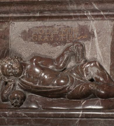 Zdjęcie nr 77: Nagrobek Grzegorza i Katarzyny Branickich znajduje się w kaplicy rodowej pod wezwaniem Najświętszej Marii Panny, na ścianie południowej, naprzeciwko wejścia. Składa się z trójosiowego cokołu i potrójnej filarowo-kolumnowej arkady z klęczącymi postaciami zmarłych po bokach adorujących znajdującą się pośrodku scenę ze zmartwychwstałym Chrystusem ukazującym się niewiernemu Tomaszowi. Całość wieńczy półkolista arkada z herbami Gryf i Kotwicz i tablicami inskrypcyjnymi. 
Dolna część artykułowa lizenami ozdobionymi motywami kandelabrowymi. W polu środkowym czaszka ze skrzyżowanymi piszczelami z inskrypcją w górnej i dolnej części: „POWIEDZ SVIETA [M]ADROSCI IESLI ZE SMIERC ZIWA / CZI MARTWA IESLI MARTWA CZEMV ZIWĄ BIWA / MALOWANA A IESLI ZIWA SMIERCIĄ CZEMV / ZOWIĄ IĄ NAD TO ZYWOT PRZECZ BIERZE KOZI/DEMV / TA IEST NA TWE PITANIE ODPOWIEC PRAWDZIWA / GDI TI ZYESZ SMIERC MARTVA GDY VMIERAS ZIWA / A IESLI ZLA CZI DOBRA CHCZES WIEDZIEC LI O TYM / IAKIS SĄM TAKĄ SMIELE SMIERC MIEĆ BĘDZIESZ PO TYM”. Na lewym polu inskrypcja „CO ZA DZIW ZEM POPIOLEM / WIEDZCIE ZESCIE WY / IAKO IA TENZE POPIOL, TO / IEDNO ZE ZYWY / BO GDIM SIĘ W PROCH ROSSIPAL / DOPIROM PRAWDZIWIE DOSZEDL, ZE CZLOWIEK TYMZE / PROCHEM CHOCIA ZYWIE / PATRZ ZE ZYWY POPIELIE A / TO POMNI SOBIE / ZES NA SWIECIE POPIOLEM / POPIOLEM I W GROBIE / A ZASZ NIEWIES CZYMEM BYL / A TERAZEM IAKI / OGLIANDAI, VWAZAIACZ ZE / SAM BEDZIESZ TAKI / BYLEM TERAS MIE NIE MASZ / IAK BIM TISZ NA SWIECIE / NIE BYL WY DZIS IESTESCIE / IUTRO NIEBEDZIECIE”. W polu cokołu „KTO TV LEZY POBOZNOSC / CNOTA OBYCZAIE / IAKICH NIERYCHLO VIZRĄ / BLISKO LEGLE KRAIE / IAKOSZ IE TAK MALY KĄT / MOGL ZACHOWAC W SOBIE / CZOSZ ALBO CNOTI LVCZKIE / GRZEBIĄ SCZIALEM W GROBIE / TILKOC TV CIALO LIEZY LIECZ / DVSZA W PRZESTRONE / NIEBIESKIE GMACHI WESŁA / KĘDI NIEZLICZONE / LATA POWIEDZIE. CZEMV IZE / MATKĄ BYLA / NIERZKAC POTOMSTWV ALIE / I SIROTOM SILA / TAKCI ZYWOT ZYWOTEM BYWA ZAKVPIONY / DOBRI FRIMARK DAC PLOCHI / ZA ON NIESKONCZONY”. Cokół zamyka wąski, silnie wysunięty gzyms z kimationem jońskim.
Trójosiowy podział nagrobka jest zachowany w partii środkowej, składającej się z trzech arkadowych wnęk, z których środkowa ujęta jest wolnostojącymi kolumnami jońskimi pokrytymi spiralnie ułożonymi pasami z motywem wici roślinnej, a sąsiednie od zewnątrz flankowane filarami pokrytymi motywami kandelabrowymi. W niezbyt głębokich niszach, których podniebienia zdobią kasetony z rozetami w kluczach uskrzydlone główki aniołków umieszczono wykonane w marmurze pińczowskim płaskorzeźby Chrystusa Zmartwychwstałego i adorujących go zmarłych, Grzegorza i Katarzynę Branickich. 
Zbawiciel jest ujęty całopostaciowo, frontalnie, w niewielkim wykroku, z głową zwróconą lekko do klęczącego po prawej stronie św. Tomasza. Jego ciało jest smukłe, wąskie w ramionach, z zaznaczonymi żebrami i mięśniami, osłonięte przewiązaną na biodrach szatą i płaszczem na lewym ramieniu. Chrystus ma pociągłą twarz, o wysokim czole, szerokich kościach policzkowych, wydatnym nosie i z głębokimi oczodołami. Przedstawiony został z długimi wąsami i brodą oraz opadającymi na ramiona, kręconymi włosami. W lewej ręce trzyma chorągiew i podtrzymuje szatę, a prawą rękę ma opuszczoną ku dołowi. 
Święty Tomasz ukazany jest z profilu, w szacie podwójnie przewiązanej w pasie sznurem i przerzuconym przez lewe ramie płaszczem. Twarz z brodą i długimi włosami, odwrócona w stronę Chrystusa. Do góry unosi również prawą rękę, zachowaną tylko do łokcia, lewą rękę trzyma ponad pasem. Figura mężczyzny wyrzeźbiona w kamieniu, polichromowana, przysłania wieniec z obłoków i uskrzydlonych głów puttów otaczający Chrystusa. 
Postacie stoją na podwójnym postumencie. W jego górnej części wyryto sentencję łacińską na prostokątnej tablicy umieszczonej w ozdobnym kartuszu, z zawiniętym spiralnie wycięciem krawędzi górnej i z dodaną w krawędzi dolnej główką uskrzydlonego putta. Napis na postumencie: „PER QVEM ET NOS / RESVRGERE DEVOTA / MENTE, CREDIMVS”. Na płycie poniżej płaskorzeźbione, leżące na prawym boku putto podpierające głowę na prawej ręce, natomiast w lewej trzymające klepsydrę. Nagie ciało, lekko przysłonięte draperią, spoczywa na poduszce z dwoma pomponami. Prawa noga jest wyprostowana, lewa zgięta w kolanie. Twarz pucołowata, z otwartymi oczami, otoczona gęstymi puklami loków. Przed dzieckiem leży czaszka. Nad nim znajduje się grawerowany kartusz z napisem: „HODIE MIHI / CRAS TIBI”. 
W arkadzie po lewej stronie przedstawiony został w trzech czwartych, zwrócony ramionami do widza Grzegorz Branicki. Postać klęczy na poduszce, szerokie dłonie złożone ma razem na piersiach, a głowę lekko uniesioną. Twarz Branickiego o pociągłych rysach, szerokich kościach policzkowych i dużych oczach, z wysokim czołem przysłoniętym zaczesanymi do przodu włosami. Ukazany z wąsami i długą, pofalowaną brodą. Ubrany jest w pełną, dekorowaną zbroję, spod której wystaje jaka i nogawice. Na szyi zawieszony łańcuch, a u stóp ostrogi. Przy nogach Branickiego leżą rękawice i hełm z trzema piórami. Nad głową wznoszą się panoplia, złożone z okrągłej tarczy i skrzyżowanych miecza, szabli, buławy, łuku, kołczanu ze strzałami i włóczni.
Po lewej stronie arkadę wypełnia ujęta z profilu, postać klęczącej na dwóch kolanach Katarzyny Branickiej. Jest ubrana w długą szubę, opadającą sztywnymi, rozchodzącymi się fałdami, u dołu załamującymi się, które zasłaniają sylwetkę. Na głowie ma czepiec przysłaniający włosy i podwikę. Twarz o łagodnych rysach, z długim nosem, małymi ustami i lekko zadartym podbródkiem. Ręce złożone razem na piersiach. Na palcach wskazującym i serdecznym lewej dłoni pierścienie, a ponad nadgarstkiem czterokrotnie nawinięty różaniec. Ponad figurą płaskorzeźbione tondo z Matką Boską z Dzieciątkiem otoczonymi wieńcem obłoków. Maria siedzi, ubrana w długą suknię, z welonem na głowie, z płaszczem zarzuconym na ramiona, którym lekko okrywa nagie Dzieciątko.
Zwieńczenie nagrobka o brzegach inkrustowanych marmurowymi kołami i elipsami, ujęte ornamentalnymi uszami, jest zakończone pasem z zawijającymi się do środkami kartuszami i równolegle ułożonymi liśćmi akantu. Tympanon wypełnia dekoracja złożona z czterech kartuszy: dwóch owalnych na tle paludamentu, zwieńczonych uskrzydloną główką anioła z godłami herbów Gryf i Kotwicz i dwóch podłużnych z inskrypcjami. Na tablicy po lewej stronie inskrypcja: „MAGNIFICO D(OMI)NO GREGORIO A RUSCA BRANICZKI OLIM VENA/TORI ET BURGRABIO CRAC(OVIENSI) CAPITANEO NIEPOŁOMIECEN(SI) VIRO / INTEGERRIMO DE REGIBVS SVIS ET RE PVB(LICA) BENE MERITO RELIGIO/NIS CATHOLICE AMANTISSIMO AMICIS FIDELISSIMO, OMNIBVS AFFABI/LI ET BENIGNO JOANNES A RUSCA BRANICZKI VENATOR CRACO(VIENSIS) CAPITANEVS NIEPOŁOMICEN(SI) MESTVS FILIUS PARENTI CHA/RISSIMO POSVIT OBYT 9 MAII A(NNO) D(OMINI) 1595 AETATIS SUE 60”. Napis wykuty po prawej stronie: “MAGNIFICAE D(OMI)NE CATHARINAE MAGNIFICI OLIM D(OMI)NI AUGUSTINI / KOTFICZ D(OMINI) SIGISMVNDI I POLONIAE REGIS STABVLI PREFECTI / VEXILIFERISQUE CURIE ET BURGRABY CRACO(VIENSIS) FILIE MATRONAE / LECTISSIME QVE CVM PVDORE ET MORVM MIRA ELEGANTIA / MARITI SUMMUM AMOREM VIRTUTE ET MODESTIA OMNIVM BENE/VOLENTIAM MERVISSET ACERBISSIMA MORTE AB OCVLIS EREPTA EST / IDEM FILIUS MATRI AMANTISSIME CVM LACRIMIS POSVIT. OBYT / 8 OCTOBRIS A(NNO) D)OMINI) 1588 AETATIS SUE 38&quot;. 
