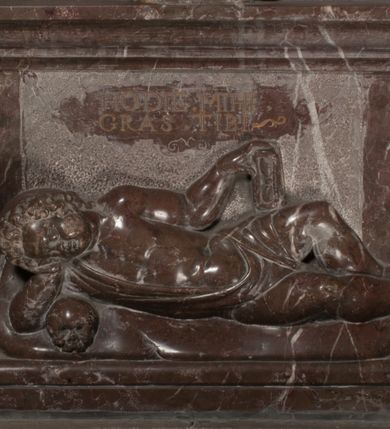 Zdjęcie nr 84: Nagrobek Grzegorza i Katarzyny Branickich znajduje się w kaplicy rodowej pod wezwaniem Najświętszej Marii Panny, na ścianie południowej, naprzeciwko wejścia. Składa się z trójosiowego cokołu i potrójnej filarowo-kolumnowej arkady z klęczącymi postaciami zmarłych po bokach adorujących znajdującą się pośrodku scenę ze zmartwychwstałym Chrystusem ukazującym się niewiernemu Tomaszowi. Całość wieńczy półkolista arkada z herbami Gryf i Kotwicz i tablicami inskrypcyjnymi. 
Dolna część artykułowa lizenami ozdobionymi motywami kandelabrowymi. W polu środkowym czaszka ze skrzyżowanymi piszczelami z inskrypcją w górnej i dolnej części: „POWIEDZ SVIETA [M]ADROSCI IESLI ZE SMIERC ZIWA / CZI MARTWA IESLI MARTWA CZEMV ZIWĄ BIWA / MALOWANA A IESLI ZIWA SMIERCIĄ CZEMV / ZOWIĄ IĄ NAD TO ZYWOT PRZECZ BIERZE KOZI/DEMV / TA IEST NA TWE PITANIE ODPOWIEC PRAWDZIWA / GDI TI ZYESZ SMIERC MARTVA GDY VMIERAS ZIWA / A IESLI ZLA CZI DOBRA CHCZES WIEDZIEC LI O TYM / IAKIS SĄM TAKĄ SMIELE SMIERC MIEĆ BĘDZIESZ PO TYM”. Na lewym polu inskrypcja „CO ZA DZIW ZEM POPIOLEM / WIEDZCIE ZESCIE WY / IAKO IA TENZE POPIOL, TO / IEDNO ZE ZYWY / BO GDIM SIĘ W PROCH ROSSIPAL / DOPIROM PRAWDZIWIE DOSZEDL, ZE CZLOWIEK TYMZE / PROCHEM CHOCIA ZYWIE / PATRZ ZE ZYWY POPIELIE A / TO POMNI SOBIE / ZES NA SWIECIE POPIOLEM / POPIOLEM I W GROBIE / A ZASZ NIEWIES CZYMEM BYL / A TERAZEM IAKI / OGLIANDAI, VWAZAIACZ ZE / SAM BEDZIESZ TAKI / BYLEM TERAS MIE NIE MASZ / IAK BIM TISZ NA SWIECIE / NIE BYL WY DZIS IESTESCIE / IUTRO NIEBEDZIECIE”. W polu cokołu „KTO TV LEZY POBOZNOSC / CNOTA OBYCZAIE / IAKICH NIERYCHLO VIZRĄ / BLISKO LEGLE KRAIE / IAKOSZ IE TAK MALY KĄT / MOGL ZACHOWAC W SOBIE / CZOSZ ALBO CNOTI LVCZKIE / GRZEBIĄ SCZIALEM W GROBIE / TILKOC TV CIALO LIEZY LIECZ / DVSZA W PRZESTRONE / NIEBIESKIE GMACHI WESŁA / KĘDI NIEZLICZONE / LATA POWIEDZIE. CZEMV IZE / MATKĄ BYLA / NIERZKAC POTOMSTWV ALIE / I SIROTOM SILA / TAKCI ZYWOT ZYWOTEM BYWA ZAKVPIONY / DOBRI FRIMARK DAC PLOCHI / ZA ON NIESKONCZONY”. Cokół zamyka wąski, silnie wysunięty gzyms z kimationem jońskim.
Trójosiowy podział nagrobka jest zachowany w partii środkowej, składającej się z trzech arkadowych wnęk, z których środkowa ujęta jest wolnostojącymi kolumnami jońskimi pokrytymi spiralnie ułożonymi pasami z motywem wici roślinnej, a sąsiednie od zewnątrz flankowane filarami pokrytymi motywami kandelabrowymi. W niezbyt głębokich niszach, których podniebienia zdobią kasetony z rozetami w kluczach uskrzydlone główki aniołków umieszczono wykonane w marmurze pińczowskim płaskorzeźby Chrystusa Zmartwychwstałego i adorujących go zmarłych, Grzegorza i Katarzynę Branickich. 
Zbawiciel jest ujęty całopostaciowo, frontalnie, w niewielkim wykroku, z głową zwróconą lekko do klęczącego po prawej stronie św. Tomasza. Jego ciało jest smukłe, wąskie w ramionach, z zaznaczonymi żebrami i mięśniami, osłonięte przewiązaną na biodrach szatą i płaszczem na lewym ramieniu. Chrystus ma pociągłą twarz, o wysokim czole, szerokich kościach policzkowych, wydatnym nosie i z głębokimi oczodołami. Przedstawiony został z długimi wąsami i brodą oraz opadającymi na ramiona, kręconymi włosami. W lewej ręce trzyma chorągiew i podtrzymuje szatę, a prawą rękę ma opuszczoną ku dołowi. 
Święty Tomasz ukazany jest z profilu, w szacie podwójnie przewiązanej w pasie sznurem i przerzuconym przez lewe ramie płaszczem. Twarz z brodą i długimi włosami, odwrócona w stronę Chrystusa. Do góry unosi również prawą rękę, zachowaną tylko do łokcia, lewą rękę trzyma ponad pasem. Figura mężczyzny wyrzeźbiona w kamieniu, polichromowana, przysłania wieniec z obłoków i uskrzydlonych głów puttów otaczający Chrystusa. 
Postacie stoją na podwójnym postumencie. W jego górnej części wyryto sentencję łacińską na prostokątnej tablicy umieszczonej w ozdobnym kartuszu, z zawiniętym spiralnie wycięciem krawędzi górnej i z dodaną w krawędzi dolnej główką uskrzydlonego putta. Napis na postumencie: „PER QVEM ET NOS / RESVRGERE DEVOTA / MENTE, CREDIMVS”. Na płycie poniżej płaskorzeźbione, leżące na prawym boku putto podpierające głowę na prawej ręce, natomiast w lewej trzymające klepsydrę. Nagie ciało, lekko przysłonięte draperią, spoczywa na poduszce z dwoma pomponami. Prawa noga jest wyprostowana, lewa zgięta w kolanie. Twarz pucołowata, z otwartymi oczami, otoczona gęstymi puklami loków. Przed dzieckiem leży czaszka. Nad nim znajduje się grawerowany kartusz z napisem: „HODIE MIHI / CRAS TIBI”. 
W arkadzie po lewej stronie przedstawiony został w trzech czwartych, zwrócony ramionami do widza Grzegorz Branicki. Postać klęczy na poduszce, szerokie dłonie złożone ma razem na piersiach, a głowę lekko uniesioną. Twarz Branickiego o pociągłych rysach, szerokich kościach policzkowych i dużych oczach, z wysokim czołem przysłoniętym zaczesanymi do przodu włosami. Ukazany z wąsami i długą, pofalowaną brodą. Ubrany jest w pełną, dekorowaną zbroję, spod której wystaje jaka i nogawice. Na szyi zawieszony łańcuch, a u stóp ostrogi. Przy nogach Branickiego leżą rękawice i hełm z trzema piórami. Nad głową wznoszą się panoplia, złożone z okrągłej tarczy i skrzyżowanych miecza, szabli, buławy, łuku, kołczanu ze strzałami i włóczni.
Po lewej stronie arkadę wypełnia ujęta z profilu, postać klęczącej na dwóch kolanach Katarzyny Branickiej. Jest ubrana w długą szubę, opadającą sztywnymi, rozchodzącymi się fałdami, u dołu załamującymi się, które zasłaniają sylwetkę. Na głowie ma czepiec przysłaniający włosy i podwikę. Twarz o łagodnych rysach, z długim nosem, małymi ustami i lekko zadartym podbródkiem. Ręce złożone razem na piersiach. Na palcach wskazującym i serdecznym lewej dłoni pierścienie, a ponad nadgarstkiem czterokrotnie nawinięty różaniec. Ponad figurą płaskorzeźbione tondo z Matką Boską z Dzieciątkiem otoczonymi wieńcem obłoków. Maria siedzi, ubrana w długą suknię, z welonem na głowie, z płaszczem zarzuconym na ramiona, którym lekko okrywa nagie Dzieciątko.
Zwieńczenie nagrobka o brzegach inkrustowanych marmurowymi kołami i elipsami, ujęte ornamentalnymi uszami, jest zakończone pasem z zawijającymi się do środkami kartuszami i równolegle ułożonymi liśćmi akantu. Tympanon wypełnia dekoracja złożona z czterech kartuszy: dwóch owalnych na tle paludamentu, zwieńczonych uskrzydloną główką anioła z godłami herbów Gryf i Kotwicz i dwóch podłużnych z inskrypcjami. Na tablicy po lewej stronie inskrypcja: „MAGNIFICO D(OMI)NO GREGORIO A RUSCA BRANICZKI OLIM VENA/TORI ET BURGRABIO CRAC(OVIENSI) CAPITANEO NIEPOŁOMIECEN(SI) VIRO / INTEGERRIMO DE REGIBVS SVIS ET RE PVB(LICA) BENE MERITO RELIGIO/NIS CATHOLICE AMANTISSIMO AMICIS FIDELISSIMO, OMNIBVS AFFABI/LI ET BENIGNO JOANNES A RUSCA BRANICZKI VENATOR CRACO(VIENSIS) CAPITANEVS NIEPOŁOMICEN(SI) MESTVS FILIUS PARENTI CHA/RISSIMO POSVIT OBYT 9 MAII A(NNO) D(OMINI) 1595 AETATIS SUE 60”. Napis wykuty po prawej stronie: “MAGNIFICAE D(OMI)NE CATHARINAE MAGNIFICI OLIM D(OMI)NI AUGUSTINI / KOTFICZ D(OMINI) SIGISMVNDI I POLONIAE REGIS STABVLI PREFECTI / VEXILIFERISQUE CURIE ET BURGRABY CRACO(VIENSIS) FILIE MATRONAE / LECTISSIME QVE CVM PVDORE ET MORVM MIRA ELEGANTIA / MARITI SUMMUM AMOREM VIRTUTE ET MODESTIA OMNIVM BENE/VOLENTIAM MERVISSET ACERBISSIMA MORTE AB OCVLIS EREPTA EST / IDEM FILIUS MATRI AMANTISSIME CVM LACRIMIS POSVIT. OBYT / 8 OCTOBRIS A(NNO) D)OMINI) 1588 AETATIS SUE 38&quot;. 
