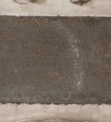 Zdjęcie nr 149: Nagrobek Grzegorza i Katarzyny Branickich znajduje się w kaplicy rodowej pod wezwaniem Najświętszej Marii Panny, na ścianie południowej, naprzeciwko wejścia. Składa się z trójosiowego cokołu i potrójnej filarowo-kolumnowej arkady z klęczącymi postaciami zmarłych po bokach adorujących znajdującą się pośrodku scenę ze zmartwychwstałym Chrystusem ukazującym się niewiernemu Tomaszowi. Całość wieńczy półkolista arkada z herbami Gryf i Kotwicz i tablicami inskrypcyjnymi. 
Dolna część artykułowa lizenami ozdobionymi motywami kandelabrowymi. W polu środkowym czaszka ze skrzyżowanymi piszczelami z inskrypcją w górnej i dolnej części: „POWIEDZ SVIETA [M]ADROSCI IESLI ZE SMIERC ZIWA / CZI MARTWA IESLI MARTWA CZEMV ZIWĄ BIWA / MALOWANA A IESLI ZIWA SMIERCIĄ CZEMV / ZOWIĄ IĄ NAD TO ZYWOT PRZECZ BIERZE KOZI/DEMV / TA IEST NA TWE PITANIE ODPOWIEC PRAWDZIWA / GDI TI ZYESZ SMIERC MARTVA GDY VMIERAS ZIWA / A IESLI ZLA CZI DOBRA CHCZES WIEDZIEC LI O TYM / IAKIS SĄM TAKĄ SMIELE SMIERC MIEĆ BĘDZIESZ PO TYM”. Na lewym polu inskrypcja „CO ZA DZIW ZEM POPIOLEM / WIEDZCIE ZESCIE WY / IAKO IA TENZE POPIOL, TO / IEDNO ZE ZYWY / BO GDIM SIĘ W PROCH ROSSIPAL / DOPIROM PRAWDZIWIE DOSZEDL, ZE CZLOWIEK TYMZE / PROCHEM CHOCIA ZYWIE / PATRZ ZE ZYWY POPIELIE A / TO POMNI SOBIE / ZES NA SWIECIE POPIOLEM / POPIOLEM I W GROBIE / A ZASZ NIEWIES CZYMEM BYL / A TERAZEM IAKI / OGLIANDAI, VWAZAIACZ ZE / SAM BEDZIESZ TAKI / BYLEM TERAS MIE NIE MASZ / IAK BIM TISZ NA SWIECIE / NIE BYL WY DZIS IESTESCIE / IUTRO NIEBEDZIECIE”. W polu cokołu „KTO TV LEZY POBOZNOSC / CNOTA OBYCZAIE / IAKICH NIERYCHLO VIZRĄ / BLISKO LEGLE KRAIE / IAKOSZ IE TAK MALY KĄT / MOGL ZACHOWAC W SOBIE / CZOSZ ALBO CNOTI LVCZKIE / GRZEBIĄ SCZIALEM W GROBIE / TILKOC TV CIALO LIEZY LIECZ / DVSZA W PRZESTRONE / NIEBIESKIE GMACHI WESŁA / KĘDI NIEZLICZONE / LATA POWIEDZIE. CZEMV IZE / MATKĄ BYLA / NIERZKAC POTOMSTWV ALIE / I SIROTOM SILA / TAKCI ZYWOT ZYWOTEM BYWA ZAKVPIONY / DOBRI FRIMARK DAC PLOCHI / ZA ON NIESKONCZONY”. Cokół zamyka wąski, silnie wysunięty gzyms z kimationem jońskim.
Trójosiowy podział nagrobka jest zachowany w partii środkowej, składającej się z trzech arkadowych wnęk, z których środkowa ujęta jest wolnostojącymi kolumnami jońskimi pokrytymi spiralnie ułożonymi pasami z motywem wici roślinnej, a sąsiednie od zewnątrz flankowane filarami pokrytymi motywami kandelabrowymi. W niezbyt głębokich niszach, których podniebienia zdobią kasetony z rozetami w kluczach uskrzydlone główki aniołków umieszczono wykonane w marmurze pińczowskim płaskorzeźby Chrystusa Zmartwychwstałego i adorujących go zmarłych, Grzegorza i Katarzynę Branickich. 
Zbawiciel jest ujęty całopostaciowo, frontalnie, w niewielkim wykroku, z głową zwróconą lekko do klęczącego po prawej stronie św. Tomasza. Jego ciało jest smukłe, wąskie w ramionach, z zaznaczonymi żebrami i mięśniami, osłonięte przewiązaną na biodrach szatą i płaszczem na lewym ramieniu. Chrystus ma pociągłą twarz, o wysokim czole, szerokich kościach policzkowych, wydatnym nosie i z głębokimi oczodołami. Przedstawiony został z długimi wąsami i brodą oraz opadającymi na ramiona, kręconymi włosami. W lewej ręce trzyma chorągiew i podtrzymuje szatę, a prawą rękę ma opuszczoną ku dołowi. 
Święty Tomasz ukazany jest z profilu, w szacie podwójnie przewiązanej w pasie sznurem i przerzuconym przez lewe ramie płaszczem. Twarz z brodą i długimi włosami, odwrócona w stronę Chrystusa. Do góry unosi również prawą rękę, zachowaną tylko do łokcia, lewą rękę trzyma ponad pasem. Figura mężczyzny wyrzeźbiona w kamieniu, polichromowana, przysłania wieniec z obłoków i uskrzydlonych głów puttów otaczający Chrystusa. 
Postacie stoją na podwójnym postumencie. W jego górnej części wyryto sentencję łacińską na prostokątnej tablicy umieszczonej w ozdobnym kartuszu, z zawiniętym spiralnie wycięciem krawędzi górnej i z dodaną w krawędzi dolnej główką uskrzydlonego putta. Napis na postumencie: „PER QVEM ET NOS / RESVRGERE DEVOTA / MENTE, CREDIMVS”. Na płycie poniżej płaskorzeźbione, leżące na prawym boku putto podpierające głowę na prawej ręce, natomiast w lewej trzymające klepsydrę. Nagie ciało, lekko przysłonięte draperią, spoczywa na poduszce z dwoma pomponami. Prawa noga jest wyprostowana, lewa zgięta w kolanie. Twarz pucołowata, z otwartymi oczami, otoczona gęstymi puklami loków. Przed dzieckiem leży czaszka. Nad nim znajduje się grawerowany kartusz z napisem: „HODIE MIHI / CRAS TIBI”. 
W arkadzie po lewej stronie przedstawiony został w trzech czwartych, zwrócony ramionami do widza Grzegorz Branicki. Postać klęczy na poduszce, szerokie dłonie złożone ma razem na piersiach, a głowę lekko uniesioną. Twarz Branickiego o pociągłych rysach, szerokich kościach policzkowych i dużych oczach, z wysokim czołem przysłoniętym zaczesanymi do przodu włosami. Ukazany z wąsami i długą, pofalowaną brodą. Ubrany jest w pełną, dekorowaną zbroję, spod której wystaje jaka i nogawice. Na szyi zawieszony łańcuch, a u stóp ostrogi. Przy nogach Branickiego leżą rękawice i hełm z trzema piórami. Nad głową wznoszą się panoplia, złożone z okrągłej tarczy i skrzyżowanych miecza, szabli, buławy, łuku, kołczanu ze strzałami i włóczni.
Po lewej stronie arkadę wypełnia ujęta z profilu, postać klęczącej na dwóch kolanach Katarzyny Branickiej. Jest ubrana w długą szubę, opadającą sztywnymi, rozchodzącymi się fałdami, u dołu załamującymi się, które zasłaniają sylwetkę. Na głowie ma czepiec przysłaniający włosy i podwikę. Twarz o łagodnych rysach, z długim nosem, małymi ustami i lekko zadartym podbródkiem. Ręce złożone razem na piersiach. Na palcach wskazującym i serdecznym lewej dłoni pierścienie, a ponad nadgarstkiem czterokrotnie nawinięty różaniec. Ponad figurą płaskorzeźbione tondo z Matką Boską z Dzieciątkiem otoczonymi wieńcem obłoków. Maria siedzi, ubrana w długą suknię, z welonem na głowie, z płaszczem zarzuconym na ramiona, którym lekko okrywa nagie Dzieciątko.
Zwieńczenie nagrobka o brzegach inkrustowanych marmurowymi kołami i elipsami, ujęte ornamentalnymi uszami, jest zakończone pasem z zawijającymi się do środkami kartuszami i równolegle ułożonymi liśćmi akantu. Tympanon wypełnia dekoracja złożona z czterech kartuszy: dwóch owalnych na tle paludamentu, zwieńczonych uskrzydloną główką anioła z godłami herbów Gryf i Kotwicz i dwóch podłużnych z inskrypcjami. Na tablicy po lewej stronie inskrypcja: „MAGNIFICO D(OMI)NO GREGORIO A RUSCA BRANICZKI OLIM VENA/TORI ET BURGRABIO CRAC(OVIENSI) CAPITANEO NIEPOŁOMIECEN(SI) VIRO / INTEGERRIMO DE REGIBVS SVIS ET RE PVB(LICA) BENE MERITO RELIGIO/NIS CATHOLICE AMANTISSIMO AMICIS FIDELISSIMO, OMNIBVS AFFABI/LI ET BENIGNO JOANNES A RUSCA BRANICZKI VENATOR CRACO(VIENSIS) CAPITANEVS NIEPOŁOMICEN(SI) MESTVS FILIUS PARENTI CHA/RISSIMO POSVIT OBYT 9 MAII A(NNO) D(OMINI) 1595 AETATIS SUE 60”. Napis wykuty po prawej stronie: “MAGNIFICAE D(OMI)NE CATHARINAE MAGNIFICI OLIM D(OMI)NI AUGUSTINI / KOTFICZ D(OMINI) SIGISMVNDI I POLONIAE REGIS STABVLI PREFECTI / VEXILIFERISQUE CURIE ET BURGRABY CRACO(VIENSIS) FILIE MATRONAE / LECTISSIME QVE CVM PVDORE ET MORVM MIRA ELEGANTIA / MARITI SUMMUM AMOREM VIRTUTE ET MODESTIA OMNIVM BENE/VOLENTIAM MERVISSET ACERBISSIMA MORTE AB OCVLIS EREPTA EST / IDEM FILIUS MATRI AMANTISSIME CVM LACRIMIS POSVIT. OBYT / 8 OCTOBRIS A(NNO) D)OMINI) 1588 AETATIS SUE 38". 
