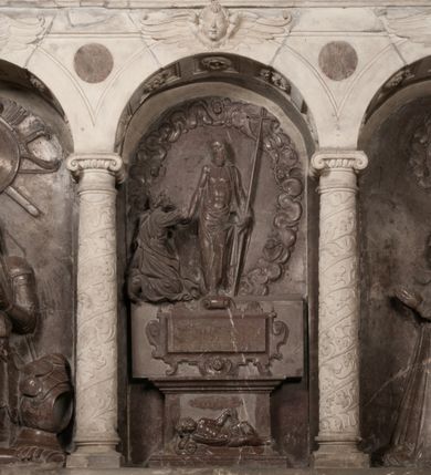 Zdjęcie nr 164: Nagrobek Grzegorza i Katarzyny Branickich znajduje się w kaplicy rodowej pod wezwaniem Najświętszej Marii Panny, na ścianie południowej, naprzeciwko wejścia. Składa się z trójosiowego cokołu i potrójnej filarowo-kolumnowej arkady z klęczącymi postaciami zmarłych po bokach adorujących znajdującą się pośrodku scenę ze zmartwychwstałym Chrystusem ukazującym się niewiernemu Tomaszowi. Całość wieńczy półkolista arkada z herbami Gryf i Kotwicz i tablicami inskrypcyjnymi. 
Dolna część artykułowa lizenami ozdobionymi motywami kandelabrowymi. W polu środkowym czaszka ze skrzyżowanymi piszczelami z inskrypcją w górnej i dolnej części: „POWIEDZ SVIETA [M]ADROSCI IESLI ZE SMIERC ZIWA / CZI MARTWA IESLI MARTWA CZEMV ZIWĄ BIWA / MALOWANA A IESLI ZIWA SMIERCIĄ CZEMV / ZOWIĄ IĄ NAD TO ZYWOT PRZECZ BIERZE KOZI/DEMV / TA IEST NA TWE PITANIE ODPOWIEC PRAWDZIWA / GDI TI ZYESZ SMIERC MARTVA GDY VMIERAS ZIWA / A IESLI ZLA CZI DOBRA CHCZES WIEDZIEC LI O TYM / IAKIS SĄM TAKĄ SMIELE SMIERC MIEĆ BĘDZIESZ PO TYM”. Na lewym polu inskrypcja „CO ZA DZIW ZEM POPIOLEM / WIEDZCIE ZESCIE WY / IAKO IA TENZE POPIOL, TO / IEDNO ZE ZYWY / BO GDIM SIĘ W PROCH ROSSIPAL / DOPIROM PRAWDZIWIE DOSZEDL, ZE CZLOWIEK TYMZE / PROCHEM CHOCIA ZYWIE / PATRZ ZE ZYWY POPIELIE A / TO POMNI SOBIE / ZES NA SWIECIE POPIOLEM / POPIOLEM I W GROBIE / A ZASZ NIEWIES CZYMEM BYL / A TERAZEM IAKI / OGLIANDAI, VWAZAIACZ ZE / SAM BEDZIESZ TAKI / BYLEM TERAS MIE NIE MASZ / IAK BIM TISZ NA SWIECIE / NIE BYL WY DZIS IESTESCIE / IUTRO NIEBEDZIECIE”. W polu cokołu „KTO TV LEZY POBOZNOSC / CNOTA OBYCZAIE / IAKICH NIERYCHLO VIZRĄ / BLISKO LEGLE KRAIE / IAKOSZ IE TAK MALY KĄT / MOGL ZACHOWAC W SOBIE / CZOSZ ALBO CNOTI LVCZKIE / GRZEBIĄ SCZIALEM W GROBIE / TILKOC TV CIALO LIEZY LIECZ / DVSZA W PRZESTRONE / NIEBIESKIE GMACHI WESŁA / KĘDI NIEZLICZONE / LATA POWIEDZIE. CZEMV IZE / MATKĄ BYLA / NIERZKAC POTOMSTWV ALIE / I SIROTOM SILA / TAKCI ZYWOT ZYWOTEM BYWA ZAKVPIONY / DOBRI FRIMARK DAC PLOCHI / ZA ON NIESKONCZONY”. Cokół zamyka wąski, silnie wysunięty gzyms z kimationem jońskim.
Trójosiowy podział nagrobka jest zachowany w partii środkowej, składającej się z trzech arkadowych wnęk, z których środkowa ujęta jest wolnostojącymi kolumnami jońskimi pokrytymi spiralnie ułożonymi pasami z motywem wici roślinnej, a sąsiednie od zewnątrz flankowane filarami pokrytymi motywami kandelabrowymi. W niezbyt głębokich niszach, których podniebienia zdobią kasetony z rozetami w kluczach uskrzydlone główki aniołków umieszczono wykonane w marmurze pińczowskim płaskorzeźby Chrystusa Zmartwychwstałego i adorujących go zmarłych, Grzegorza i Katarzynę Branickich. 
Zbawiciel jest ujęty całopostaciowo, frontalnie, w niewielkim wykroku, z głową zwróconą lekko do klęczącego po prawej stronie św. Tomasza. Jego ciało jest smukłe, wąskie w ramionach, z zaznaczonymi żebrami i mięśniami, osłonięte przewiązaną na biodrach szatą i płaszczem na lewym ramieniu. Chrystus ma pociągłą twarz, o wysokim czole, szerokich kościach policzkowych, wydatnym nosie i z głębokimi oczodołami. Przedstawiony został z długimi wąsami i brodą oraz opadającymi na ramiona, kręconymi włosami. W lewej ręce trzyma chorągiew i podtrzymuje szatę, a prawą rękę ma opuszczoną ku dołowi. 
Święty Tomasz ukazany jest z profilu, w szacie podwójnie przewiązanej w pasie sznurem i przerzuconym przez lewe ramie płaszczem. Twarz z brodą i długimi włosami, odwrócona w stronę Chrystusa. Do góry unosi również prawą rękę, zachowaną tylko do łokcia, lewą rękę trzyma ponad pasem. Figura mężczyzny wyrzeźbiona w kamieniu, polichromowana, przysłania wieniec z obłoków i uskrzydlonych głów puttów otaczający Chrystusa. 
Postacie stoją na podwójnym postumencie. W jego górnej części wyryto sentencję łacińską na prostokątnej tablicy umieszczonej w ozdobnym kartuszu, z zawiniętym spiralnie wycięciem krawędzi górnej i z dodaną w krawędzi dolnej główką uskrzydlonego putta. Napis na postumencie: „PER QVEM ET NOS / RESVRGERE DEVOTA / MENTE, CREDIMVS”. Na płycie poniżej płaskorzeźbione, leżące na prawym boku putto podpierające głowę na prawej ręce, natomiast w lewej trzymające klepsydrę. Nagie ciało, lekko przysłonięte draperią, spoczywa na poduszce z dwoma pomponami. Prawa noga jest wyprostowana, lewa zgięta w kolanie. Twarz pucołowata, z otwartymi oczami, otoczona gęstymi puklami loków. Przed dzieckiem leży czaszka. Nad nim znajduje się grawerowany kartusz z napisem: „HODIE MIHI / CRAS TIBI”. 
W arkadzie po lewej stronie przedstawiony został w trzech czwartych, zwrócony ramionami do widza Grzegorz Branicki. Postać klęczy na poduszce, szerokie dłonie złożone ma razem na piersiach, a głowę lekko uniesioną. Twarz Branickiego o pociągłych rysach, szerokich kościach policzkowych i dużych oczach, z wysokim czołem przysłoniętym zaczesanymi do przodu włosami. Ukazany z wąsami i długą, pofalowaną brodą. Ubrany jest w pełną, dekorowaną zbroję, spod której wystaje jaka i nogawice. Na szyi zawieszony łańcuch, a u stóp ostrogi. Przy nogach Branickiego leżą rękawice i hełm z trzema piórami. Nad głową wznoszą się panoplia, złożone z okrągłej tarczy i skrzyżowanych miecza, szabli, buławy, łuku, kołczanu ze strzałami i włóczni.
Po lewej stronie arkadę wypełnia ujęta z profilu, postać klęczącej na dwóch kolanach Katarzyny Branickiej. Jest ubrana w długą szubę, opadającą sztywnymi, rozchodzącymi się fałdami, u dołu załamującymi się, które zasłaniają sylwetkę. Na głowie ma czepiec przysłaniający włosy i podwikę. Twarz o łagodnych rysach, z długim nosem, małymi ustami i lekko zadartym podbródkiem. Ręce złożone razem na piersiach. Na palcach wskazującym i serdecznym lewej dłoni pierścienie, a ponad nadgarstkiem czterokrotnie nawinięty różaniec. Ponad figurą płaskorzeźbione tondo z Matką Boską z Dzieciątkiem otoczonymi wieńcem obłoków. Maria siedzi, ubrana w długą suknię, z welonem na głowie, z płaszczem zarzuconym na ramiona, którym lekko okrywa nagie Dzieciątko.
Zwieńczenie nagrobka o brzegach inkrustowanych marmurowymi kołami i elipsami, ujęte ornamentalnymi uszami, jest zakończone pasem z zawijającymi się do środkami kartuszami i równolegle ułożonymi liśćmi akantu. Tympanon wypełnia dekoracja złożona z czterech kartuszy: dwóch owalnych na tle paludamentu, zwieńczonych uskrzydloną główką anioła z godłami herbów Gryf i Kotwicz i dwóch podłużnych z inskrypcjami. Na tablicy po lewej stronie inskrypcja: „MAGNIFICO D(OMI)NO GREGORIO A RUSCA BRANICZKI OLIM VENA/TORI ET BURGRABIO CRAC(OVIENSI) CAPITANEO NIEPOŁOMIECEN(SI) VIRO / INTEGERRIMO DE REGIBVS SVIS ET RE PVB(LICA) BENE MERITO RELIGIO/NIS CATHOLICE AMANTISSIMO AMICIS FIDELISSIMO, OMNIBVS AFFABI/LI ET BENIGNO JOANNES A RUSCA BRANICZKI VENATOR CRACO(VIENSIS) CAPITANEVS NIEPOŁOMICEN(SI) MESTVS FILIUS PARENTI CHA/RISSIMO POSVIT OBYT 9 MAII A(NNO) D(OMINI) 1595 AETATIS SUE 60”. Napis wykuty po prawej stronie: “MAGNIFICAE D(OMI)NE CATHARINAE MAGNIFICI OLIM D(OMI)NI AUGUSTINI / KOTFICZ D(OMINI) SIGISMVNDI I POLONIAE REGIS STABVLI PREFECTI / VEXILIFERISQUE CURIE ET BURGRABY CRACO(VIENSIS) FILIE MATRONAE / LECTISSIME QVE CVM PVDORE ET MORVM MIRA ELEGANTIA / MARITI SUMMUM AMOREM VIRTUTE ET MODESTIA OMNIVM BENE/VOLENTIAM MERVISSET ACERBISSIMA MORTE AB OCVLIS EREPTA EST / IDEM FILIUS MATRI AMANTISSIME CVM LACRIMIS POSVIT. OBYT / 8 OCTOBRIS A(NNO) D)OMINI) 1588 AETATIS SUE 38". 
