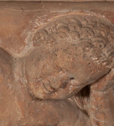 Zdjęcie nr 8: Epitafium złożone z dwóch tablic w kształcie leżącego prostokąta, dolnej z przedstawieniem zmarłego i górnej z inskrypcją. W dolnej tablicy, ujętej arabeską, ukazane nagie dziecko, leżące na marszczonej w równoległe fałdy tkaninie biegnącej pomiędzy jego udami. Nogi ma skrzyżowane. Prawa jest ułożona prosto, a lewa ugięta w kolanie. Jego głowa jest wsparta na zgiętej w łokciu lewej ręce, drugą rękę  ma ułożoną wzdłuż tułowia, w dłoni trzyma różę. Twarz jest pełna, nos krótki i szeroki, oczy zamknięte, usta pełne, lekko uśmiechnięte, na głowie krótkie, kręcone włosy. Pod lewą ręką znajduje się ludzka czaszka. Na tablicy powyżej inskrypcja "GENEROSOVS DOMINVS MARTINVS / CŻVRILO DE VIGNANO VICE VENA/TOR T[E]RRE CRACOVIENSIS ET / CAPITANEVS NIEPOL[O]MICENSIS / FILIO SVO PRIMOGENITO IOANNI / PONICNRAVIT QVI NATVS OBIIT / 26 IANVARII ANNO D(OMI)NI 1560  [V]IXIT HORIS TRIBVS".
