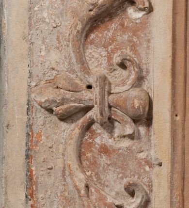 Zdjęcie nr 16: Epitafium złożone z dwóch tablic w kształcie leżącego prostokąta, dolnej z przedstawieniem zmarłego i górnej z inskrypcją. W dolnej tablicy, ujętej arabeską, ukazane nagie dziecko, leżące na marszczonej w równoległe fałdy tkaninie biegnącej pomiędzy jego udami. Nogi ma skrzyżowane. Prawa jest ułożona prosto, a lewa ugięta w kolanie. Jego głowa jest wsparta na zgiętej w łokciu lewej ręce, drugą rękę  ma ułożoną wzdłuż tułowia, w dłoni trzyma różę. Twarz jest pełna, nos krótki i szeroki, oczy zamknięte, usta pełne, lekko uśmiechnięte, na głowie krótkie, kręcone włosy. Pod lewą ręką znajduje się ludzka czaszka. Na tablicy powyżej inskrypcja "GENEROSOVS DOMINVS MARTINVS / CŻVRILO DE VIGNANO VICE VENA/TOR T[E]RRE CRACOVIENSIS ET / CAPITANEVS NIEPOL[O]MICENSIS / FILIO SVO PRIMOGENITO IOANNI / PONICNRAVIT QVI NATVS OBIIT / 26 IANVARII ANNO D(OMI)NI 1560  [V]IXIT HORIS TRIBVS".
