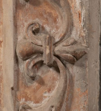 Zdjęcie nr 15: Epitafium złożone z dwóch tablic w kształcie leżącego prostokąta, dolnej z przedstawieniem zmarłego i górnej z inskrypcją. W dolnej tablicy, ujętej arabeską, ukazane nagie dziecko, leżące na marszczonej w równoległe fałdy tkaninie biegnącej pomiędzy jego udami. Nogi ma skrzyżowane. Prawa jest ułożona prosto, a lewa ugięta w kolanie. Jego głowa jest wsparta na zgiętej w łokciu lewej ręce, drugą rękę  ma ułożoną wzdłuż tułowia, w dłoni trzyma różę. Twarz jest pełna, nos krótki i szeroki, oczy zamknięte, usta pełne, lekko uśmiechnięte, na głowie krótkie, kręcone włosy. Pod lewą ręką znajduje się ludzka czaszka. Na tablicy powyżej inskrypcja "GENEROSOVS DOMINVS MARTINVS / CŻVRILO DE VIGNANO VICE VENA/TOR T[E]RRE CRACOVIENSIS ET / CAPITANEVS NIEPOL[O]MICENSIS / FILIO SVO PRIMOGENITO IOANNI / PONICNRAVIT QVI NATVS OBIIT / 26 IANVARII ANNO D(OMI)NI 1560  [V]IXIT HORIS TRIBVS".
