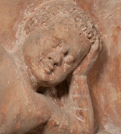 Zdjęcie nr 14: Epitafium złożone z dwóch tablic w kształcie leżącego prostokąta, dolnej z przedstawieniem zmarłego i górnej z inskrypcją. W dolnej tablicy, ujętej arabeską, ukazane nagie dziecko, leżące na marszczonej w równoległe fałdy tkaninie biegnącej pomiędzy jego udami. Nogi ma skrzyżowane. Prawa jest ułożona prosto, a lewa ugięta w kolanie. Jego głowa jest wsparta na zgiętej w łokciu lewej ręce, drugą rękę  ma ułożoną wzdłuż tułowia, w dłoni trzyma różę. Twarz jest pełna, nos krótki i szeroki, oczy zamknięte, usta pełne, lekko uśmiechnięte, na głowie krótkie, kręcone włosy. Pod lewą ręką znajduje się ludzka czaszka. Na tablicy powyżej inskrypcja &quot;GENEROSOVS DOMINVS MARTINVS / CŻVRILO DE VIGNANO VICE VENA/TOR T[E]RRE CRACOVIENSIS ET / CAPITANEVS NIEPOL[O]MICENSIS / FILIO SVO PRIMOGENITO IOANNI / PONICNRAVIT QVI NATVS OBIIT / 26 IANVARII ANNO D(OMI)NI 1560  [V]IXIT HORIS TRIBVS&quot;.
