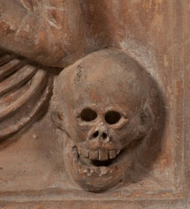 Zdjęcie nr 17: Epitafium złożone z dwóch tablic w kształcie leżącego prostokąta, dolnej z przedstawieniem zmarłego i górnej z inskrypcją. W dolnej tablicy, ujętej arabeską, ukazane nagie dziecko, leżące na marszczonej w równoległe fałdy tkaninie biegnącej pomiędzy jego udami. Nogi ma skrzyżowane. Prawa jest ułożona prosto, a lewa ugięta w kolanie. Jego głowa jest wsparta na zgiętej w łokciu lewej ręce, drugą rękę  ma ułożoną wzdłuż tułowia, w dłoni trzyma różę. Twarz jest pełna, nos krótki i szeroki, oczy zamknięte, usta pełne, lekko uśmiechnięte, na głowie krótkie, kręcone włosy. Pod lewą ręką znajduje się ludzka czaszka. Na tablicy powyżej inskrypcja "GENEROSOVS DOMINVS MARTINVS / CŻVRILO DE VIGNANO VICE VENA/TOR T[E]RRE CRACOVIENSIS ET / CAPITANEVS NIEPOL[O]MICENSIS / FILIO SVO PRIMOGENITO IOANNI / PONICNRAVIT QVI NATVS OBIIT / 26 IANVARII ANNO D(OMI)NI 1560  [V]IXIT HORIS TRIBVS".
