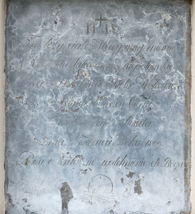 Zdjęcie nr 1: Płyta w formie stojącego prostokąta. W górnej części ryty monogram IHS zwieńczony krzyżem. W polu inskrypcja „Tu leży ciało Maryanny Gniewinski / C(esarsko) K(rólewskiego) Prefekta Salinarnego Niepołomskiego / oraz Dziedzica Dóbr Wokowic / Nayukochańszey Córki. / Zeszła z tego Świata / Dnia 5go Marca Roku 1809. / Prosi o serdeczne westchnienie do Boga”. W dolnej części płyty ryta czaszka ze skrzyzowanymi piszczelami. 